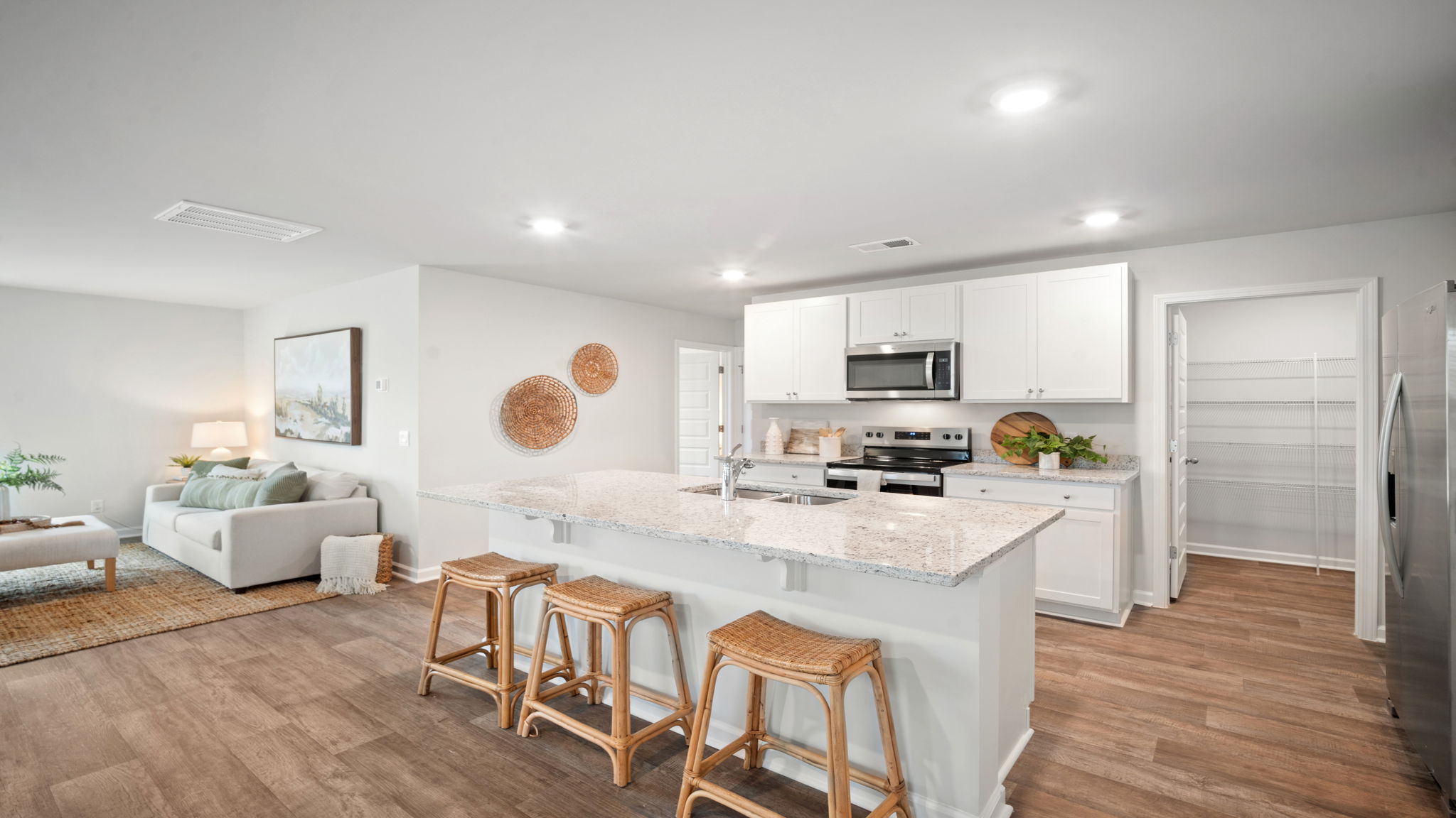 Kitchen with a view of the island with a stainless dishwasher and the dining area in the background