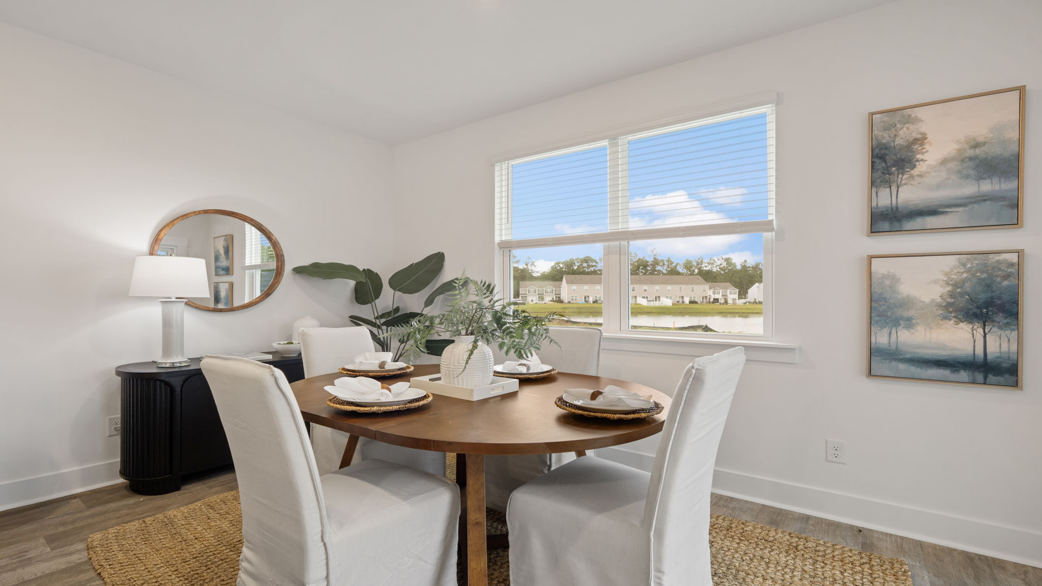 Dining space with large windows, neutral finishes, and natural light.