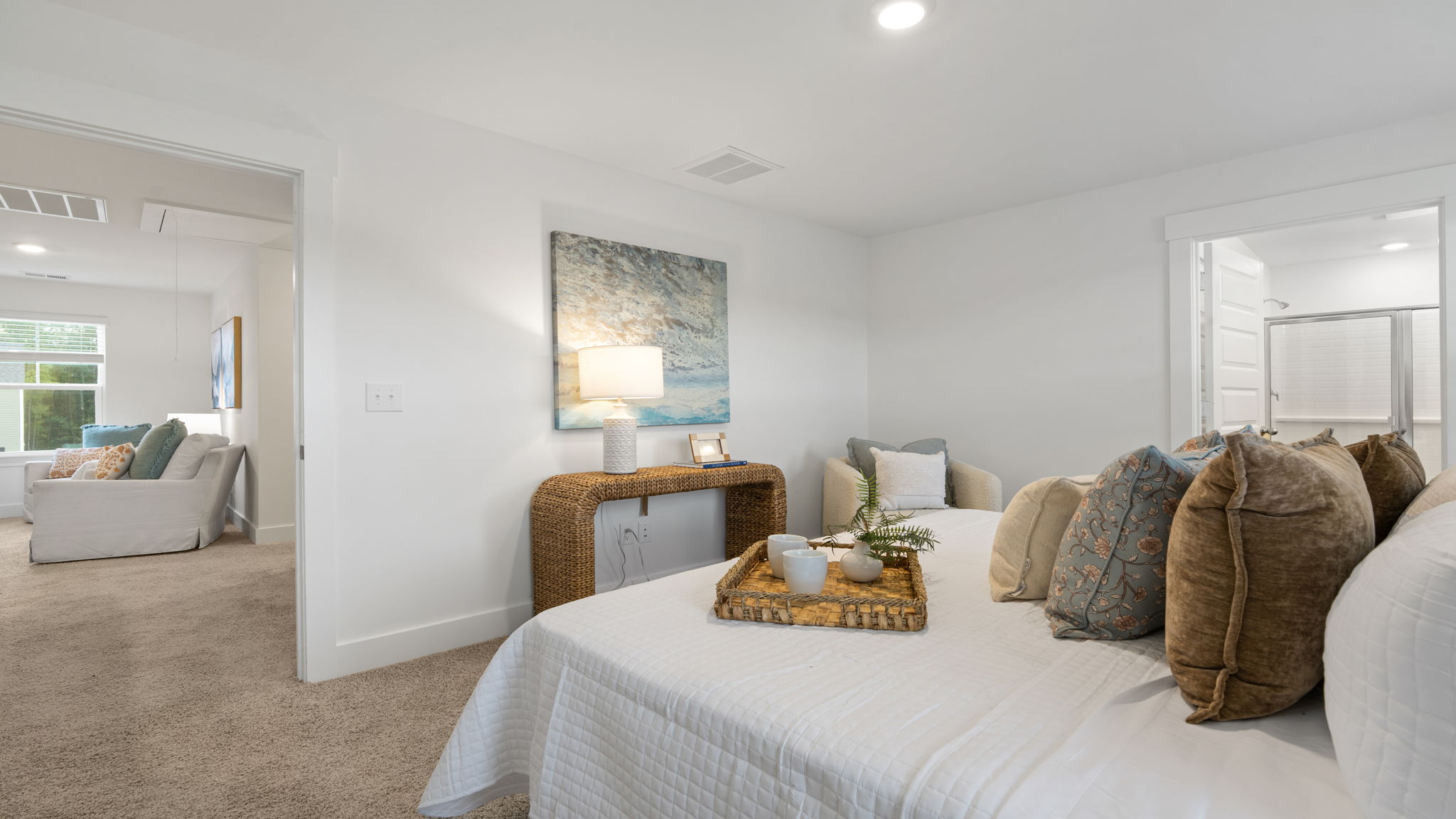 Bedroom with neutral carpet, multiple windows, and coordinated furnishings.