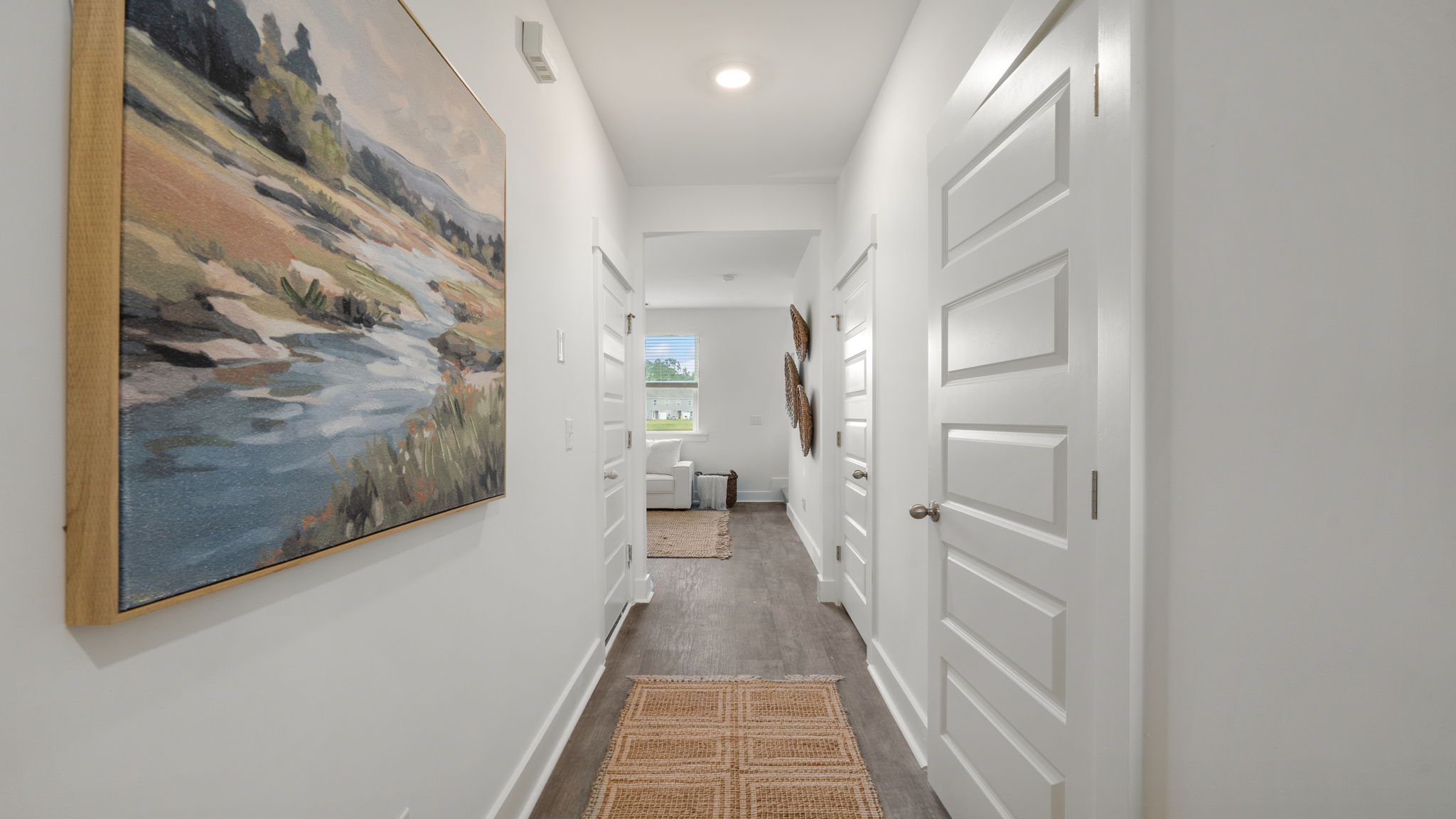 Bright entry hallway in the Cabral A at 116 Chipmunk Trail with white doors and coastal-inspired wall art.