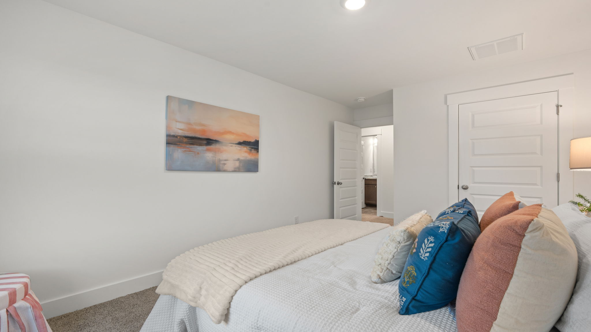 Bedroom with neutral carpet, window, and coordinated furnishings.