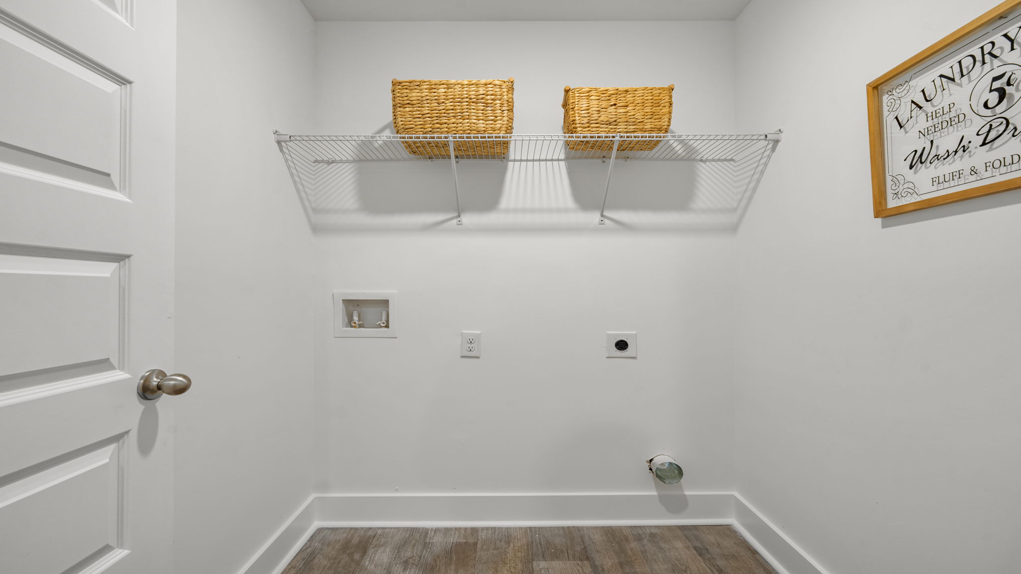 Laundry room with built-in wire shelf and light neutral finishes.