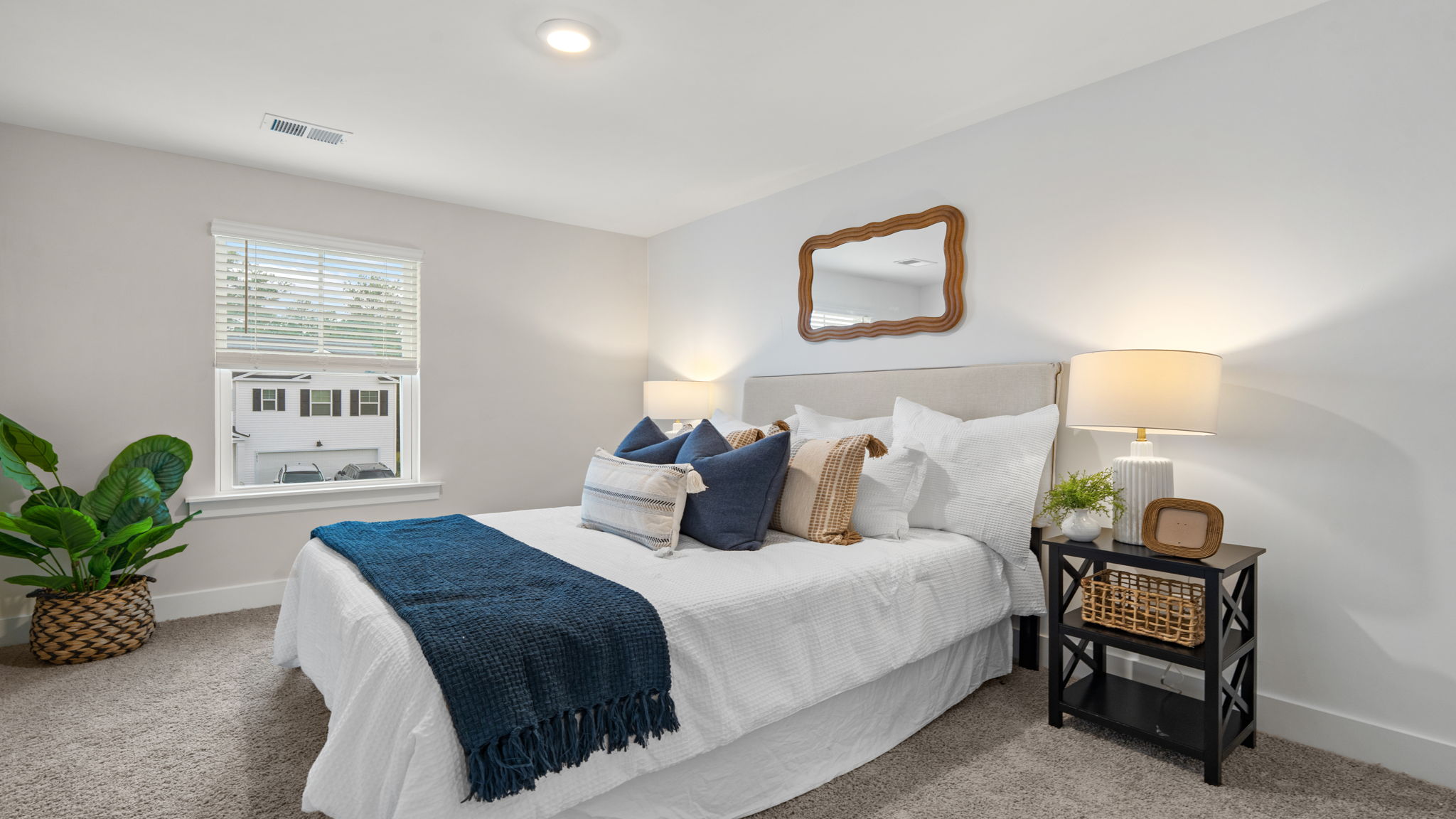 Bedroom with window, neutral carpet, and coordinated furnishings.