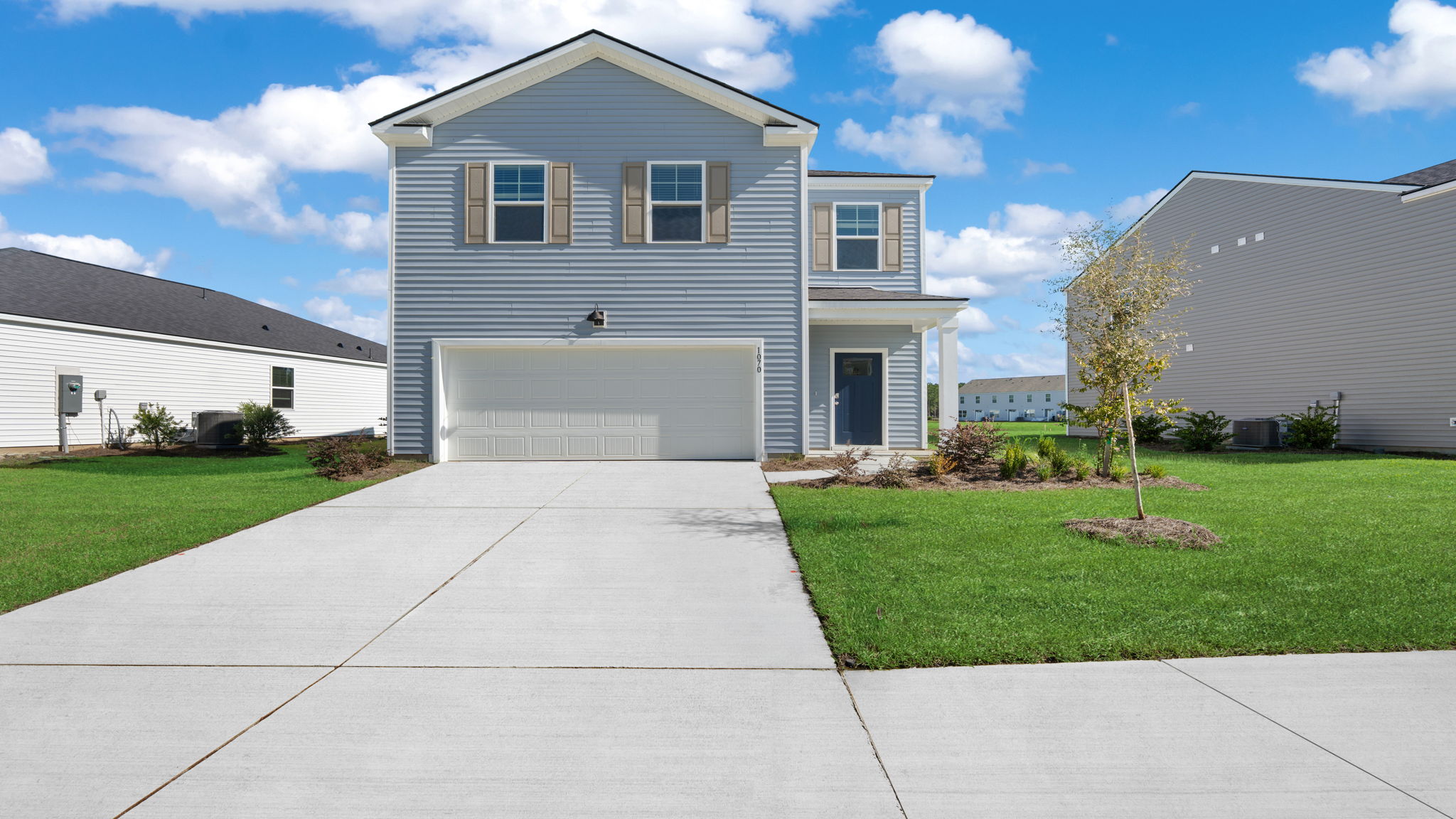 Front exterior of 116 Chipmunk Trail featuring a two-story design, attached garage, driveway, and landscaped yard.