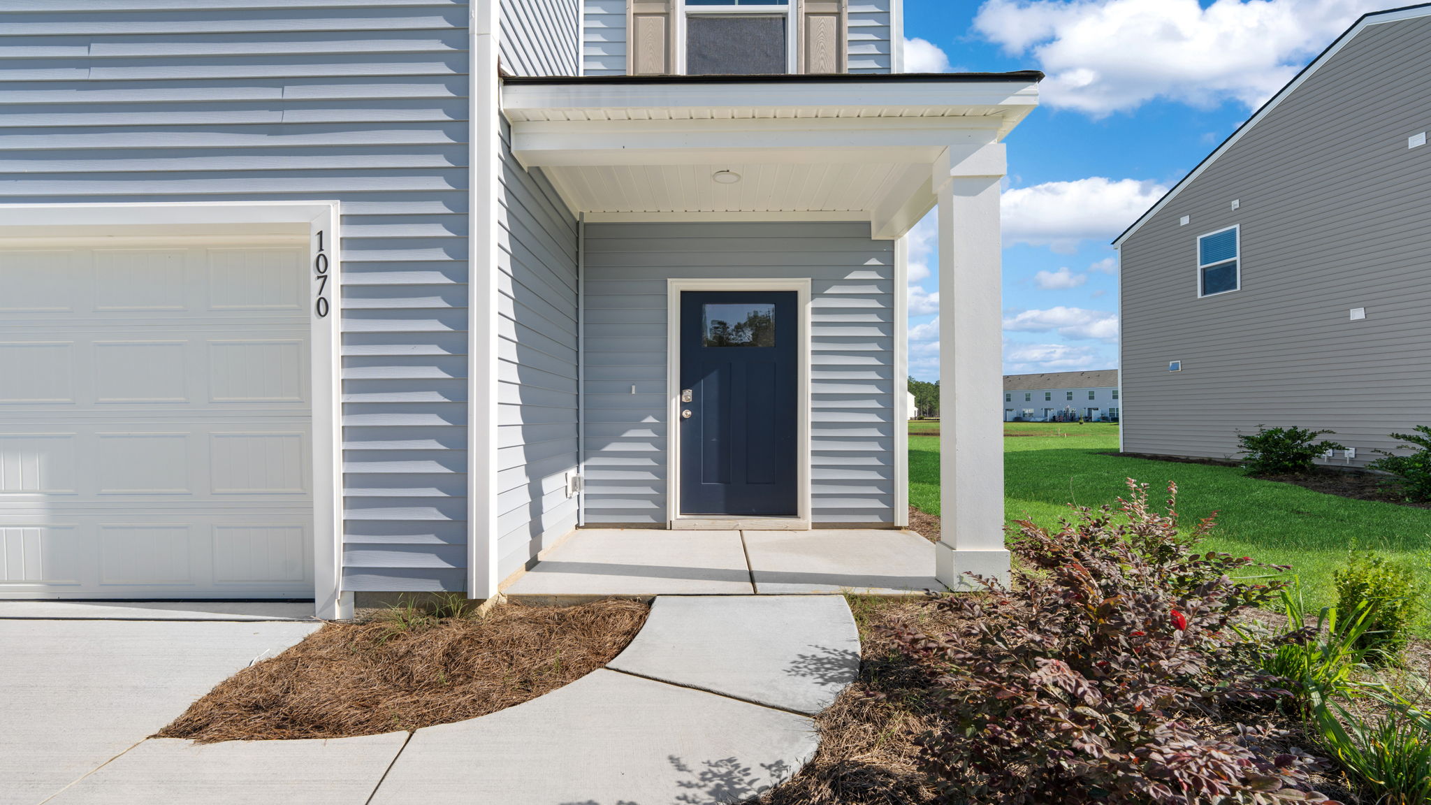 Close exterior view of the covered front entry and attached garage at 116 Chipmunk Trail.