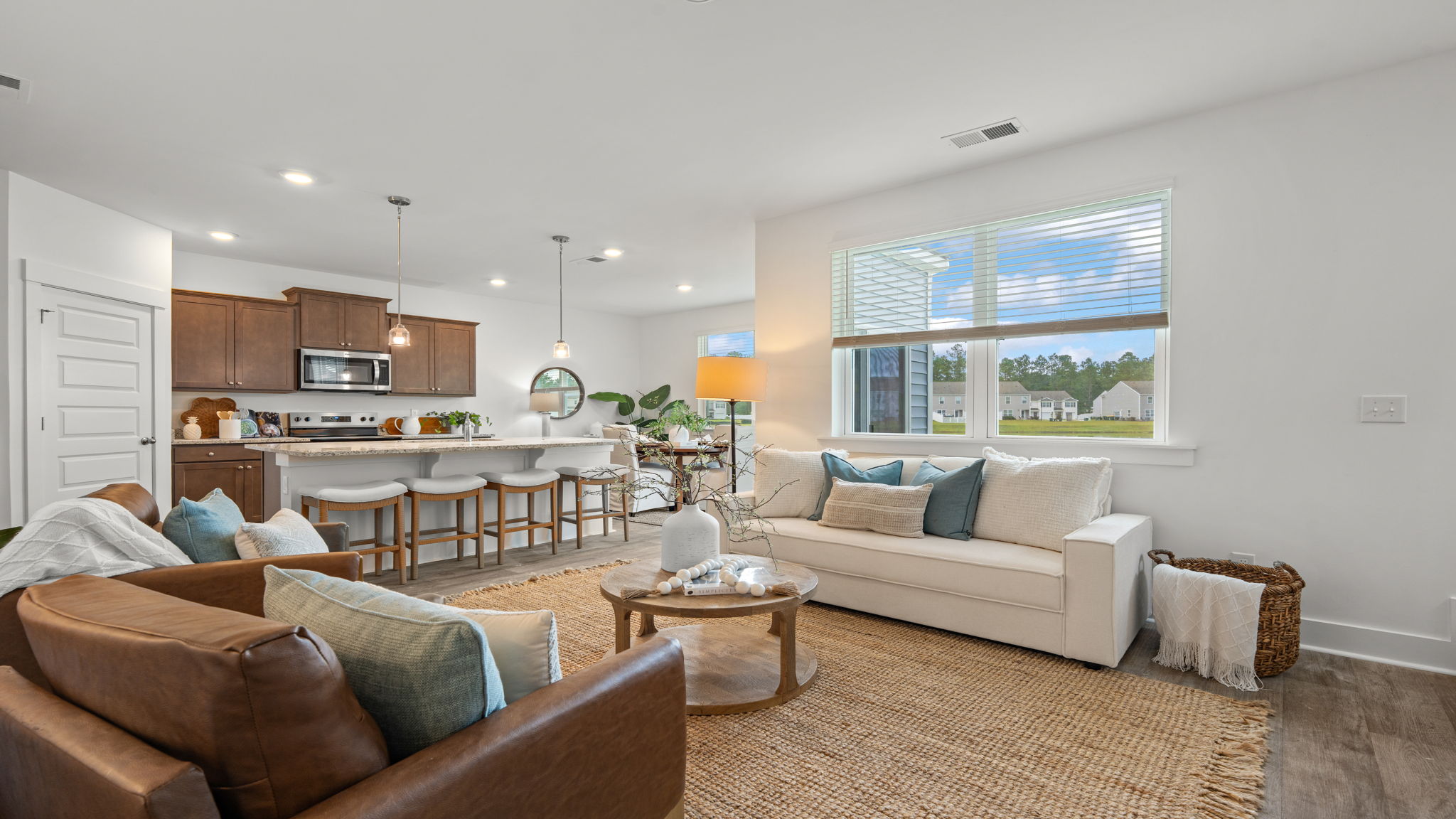 Open-concept living room and kitchen featuring abundant natural light and modern finishes.