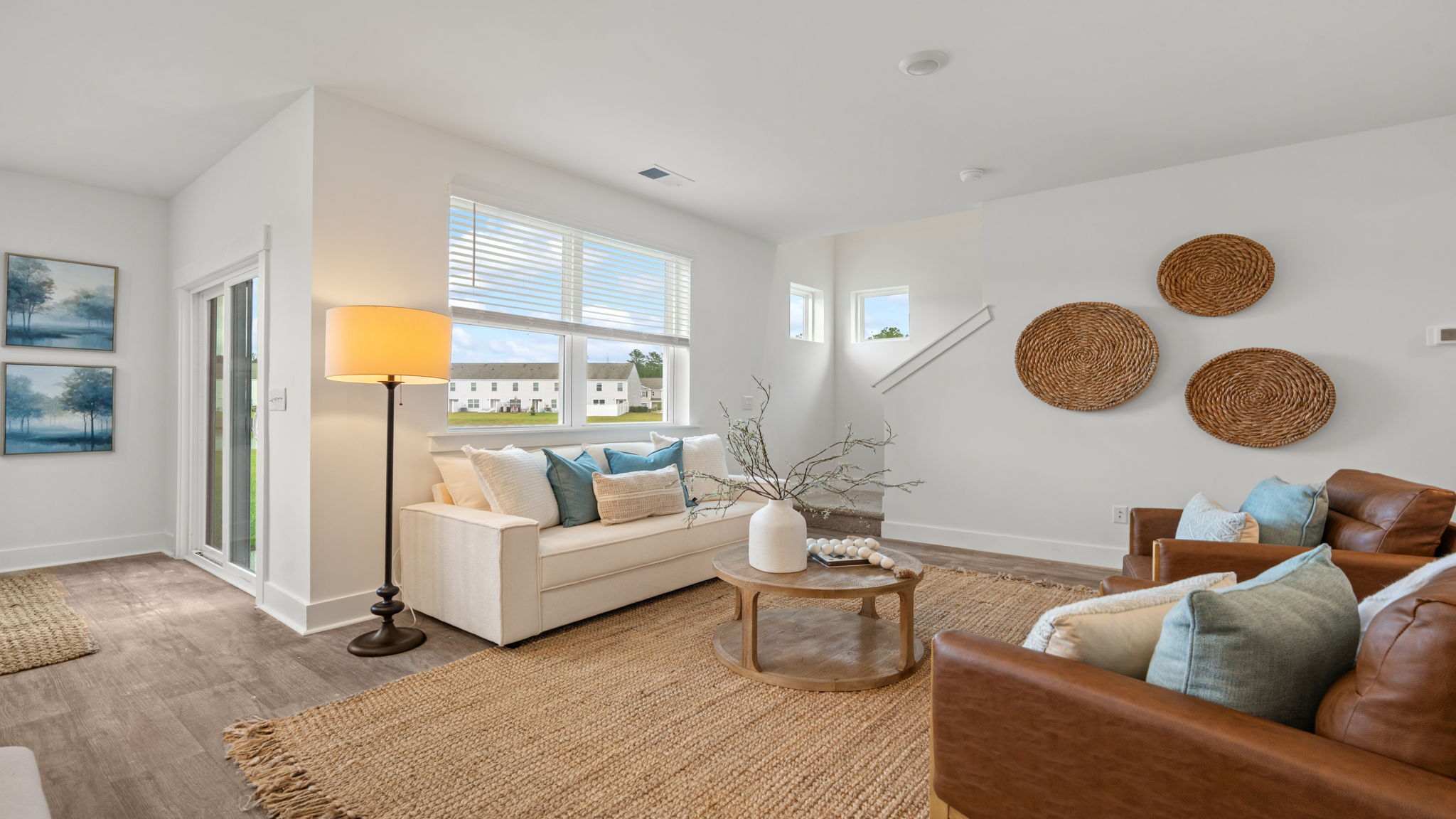 Bright living room with large windows, neutral flooring, and open layout.