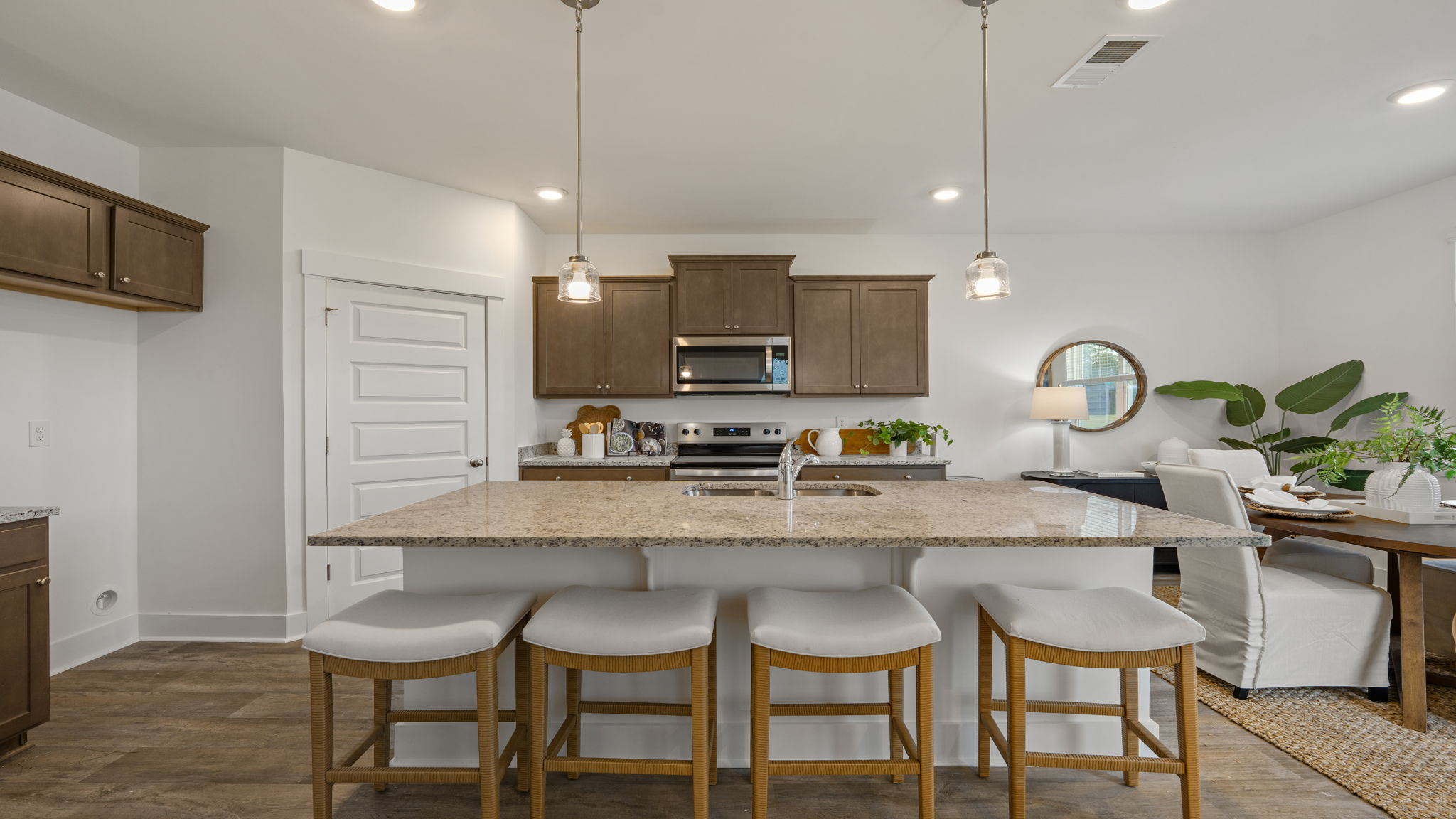 Kitchen with center island, bar seating, stainless steel appliances, and pendant lighting.