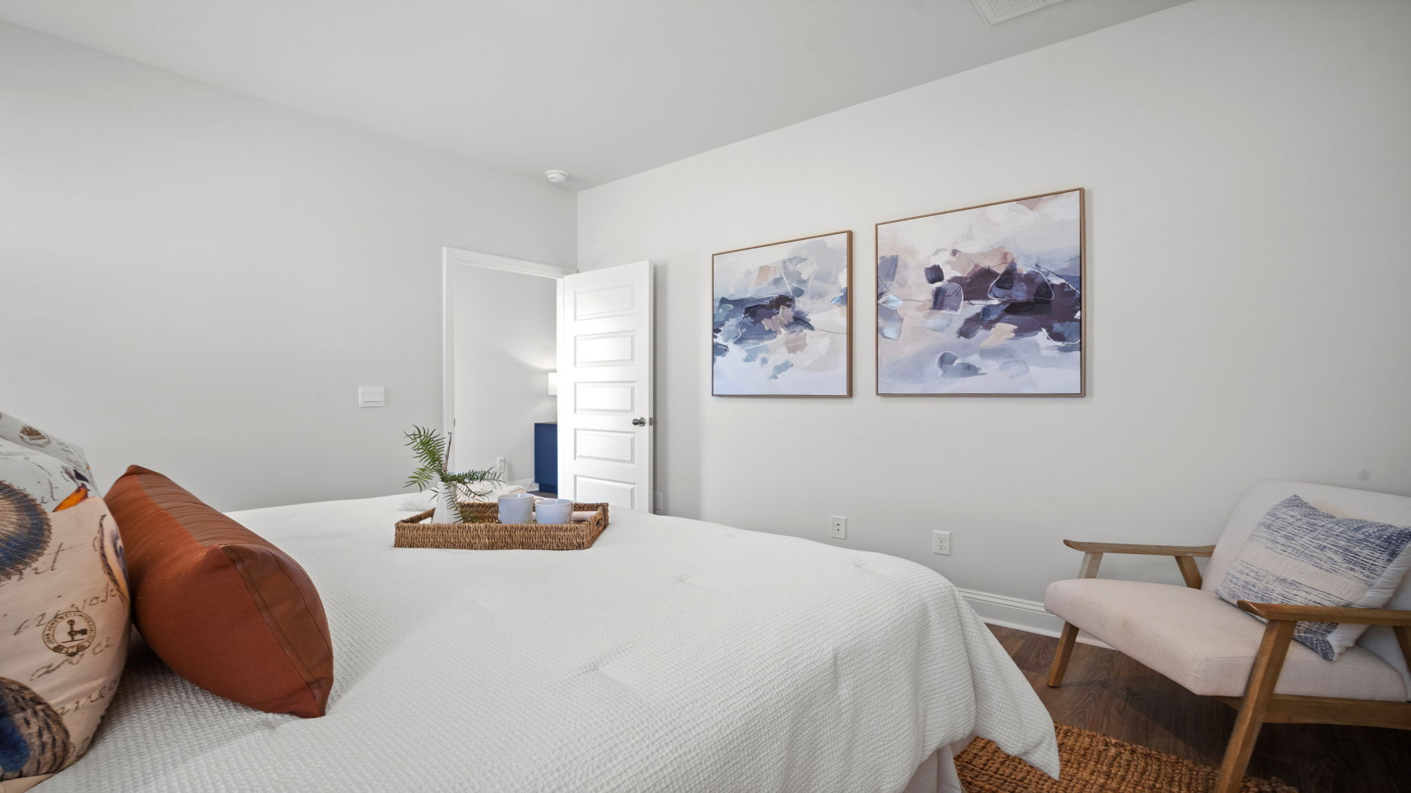 Primary bedroom with hardwood floors, large windows, and trey ceilings.