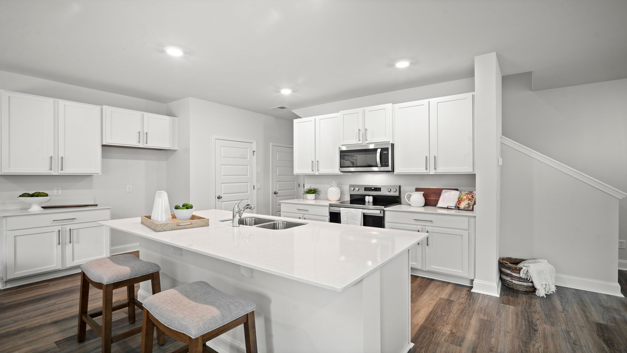 Kitchen area with granite countertops, large island, cabinets, tile backsplash, and stainless steel appliances
