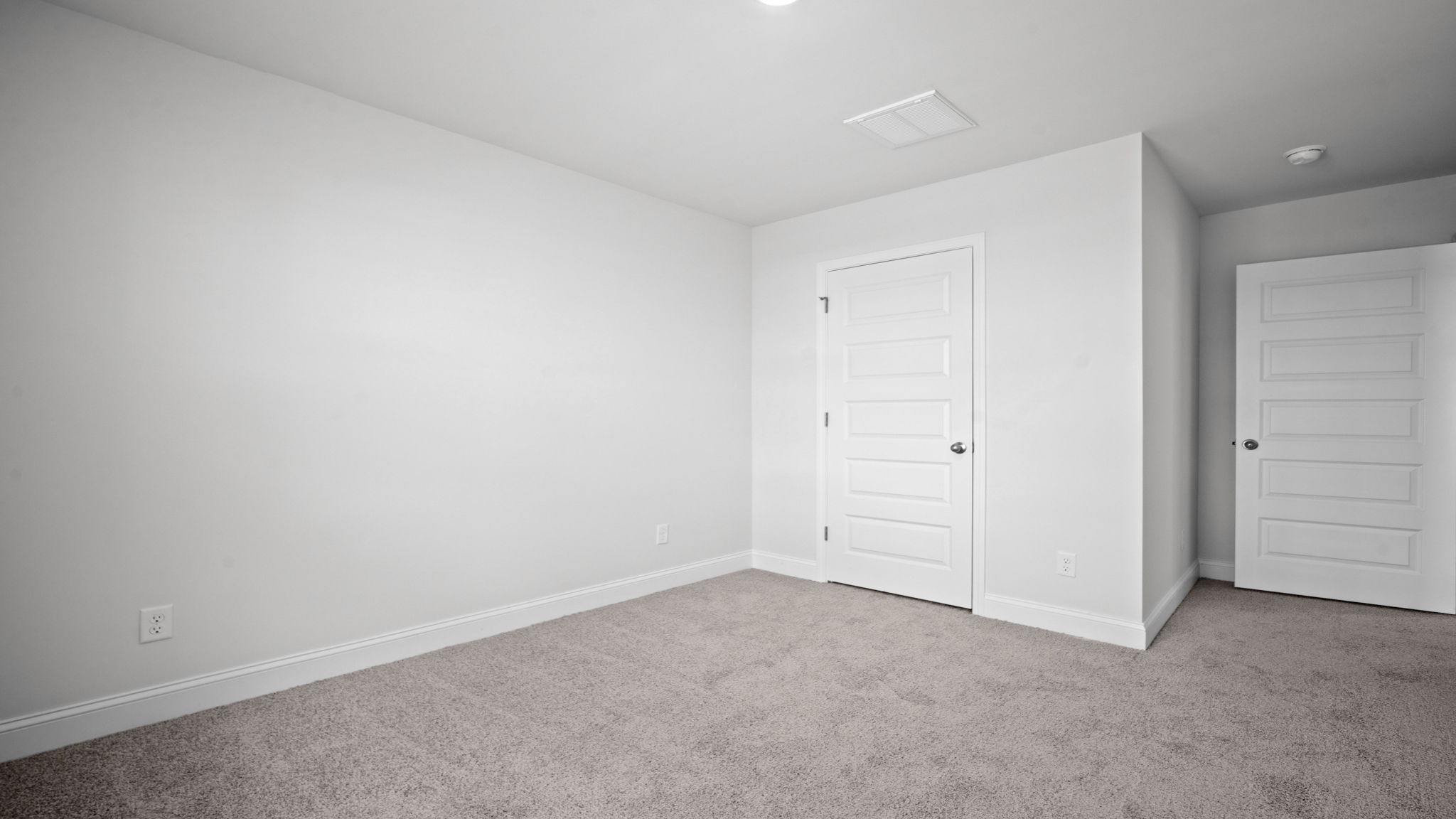 Bedroom with closet door and entry door.