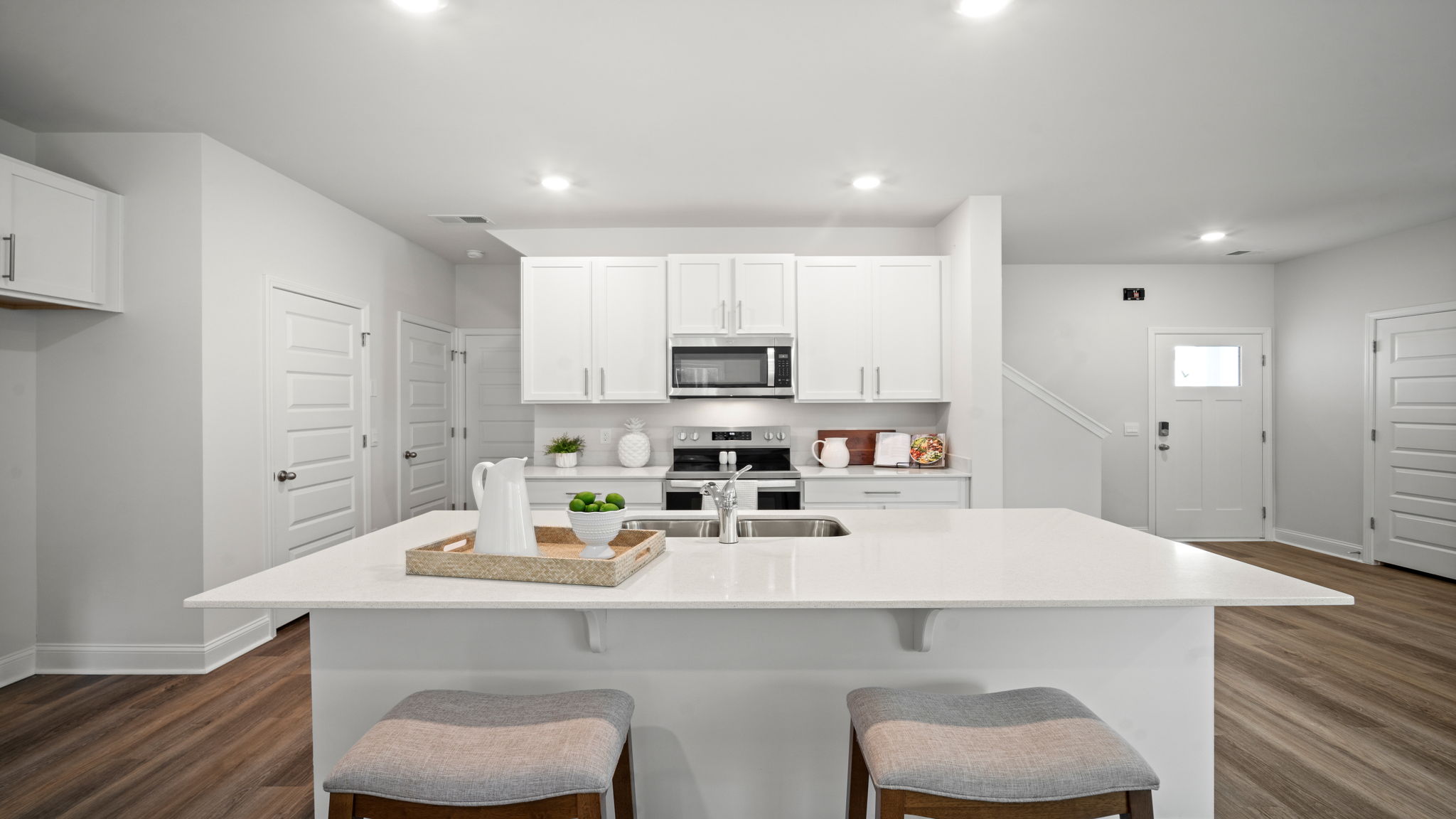 Kitchen area with granite countertops, large island, cabinets, tile backsplash, and stainless steel appliances