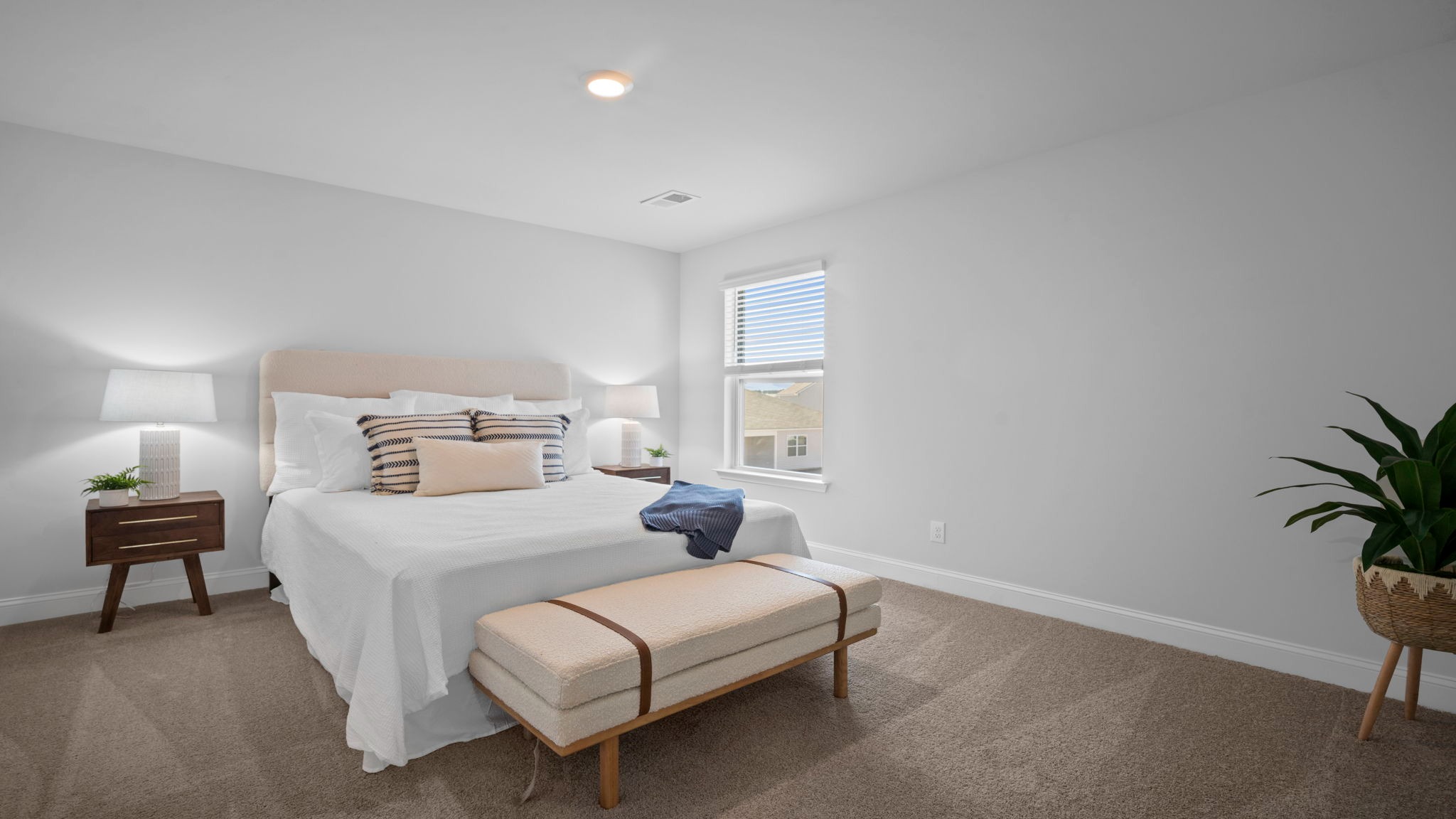 Guest bedroom with a bed, bench and a side table