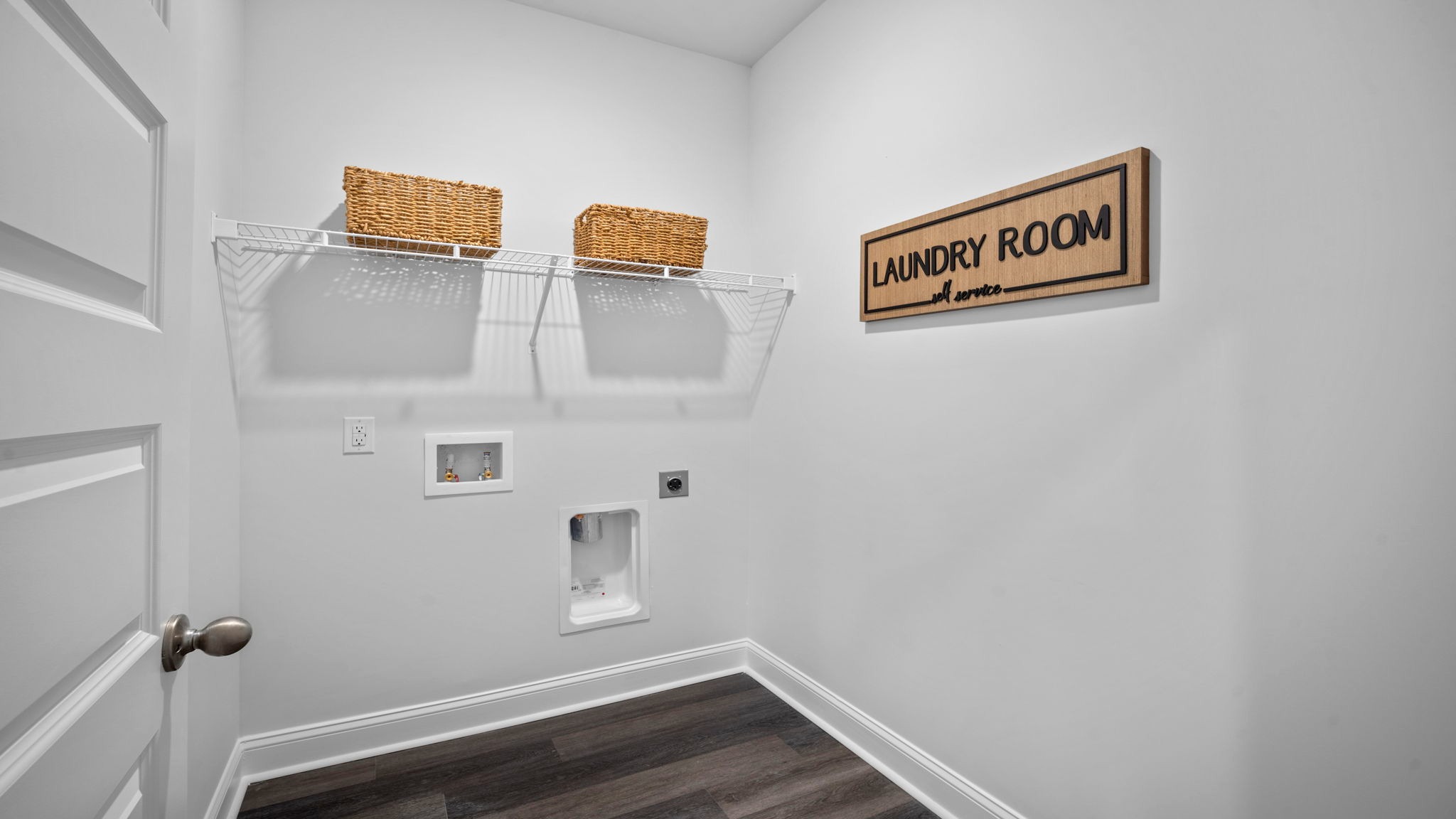 Spacious laundry area has room for a washer and dryer with built in shelves.