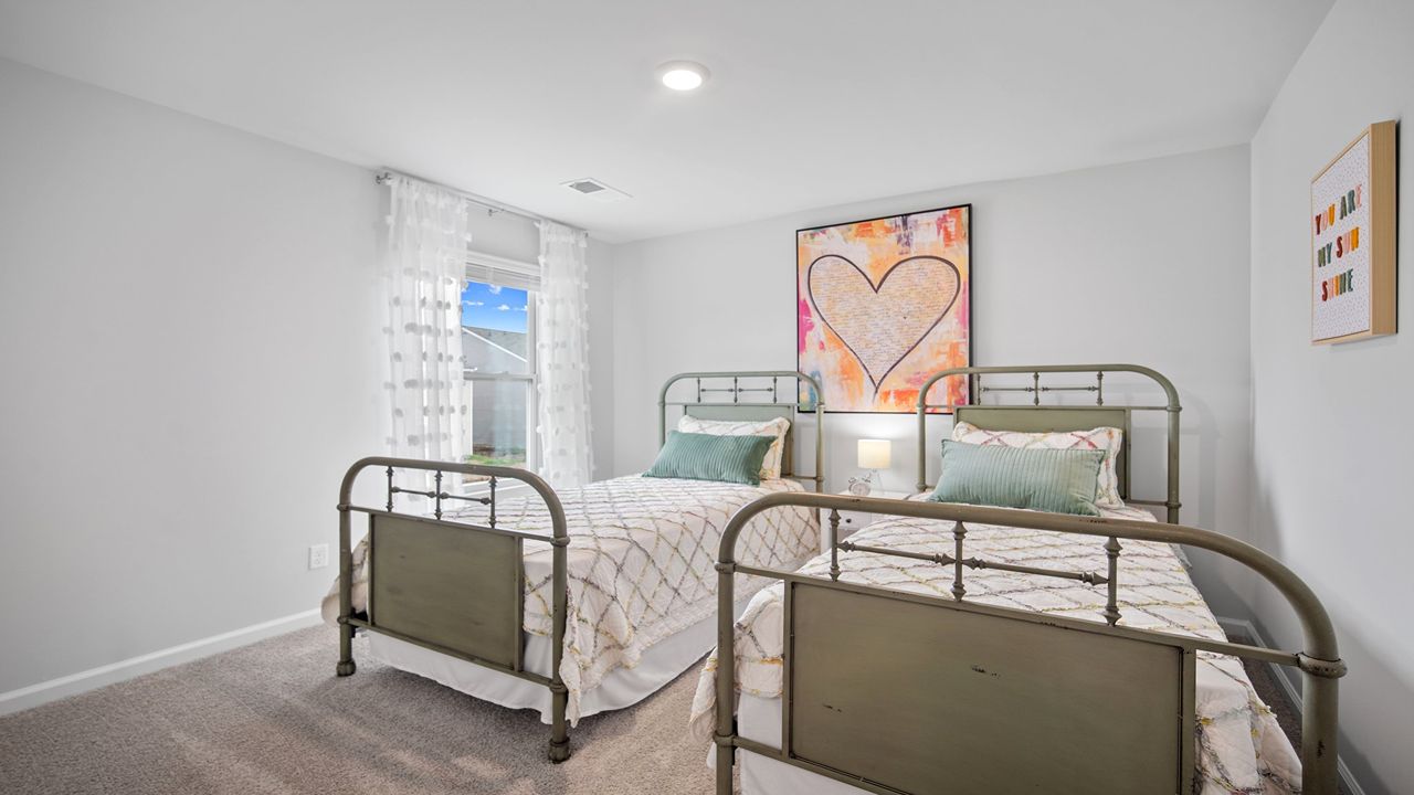 Guest bedroom with two beds and simple decor.