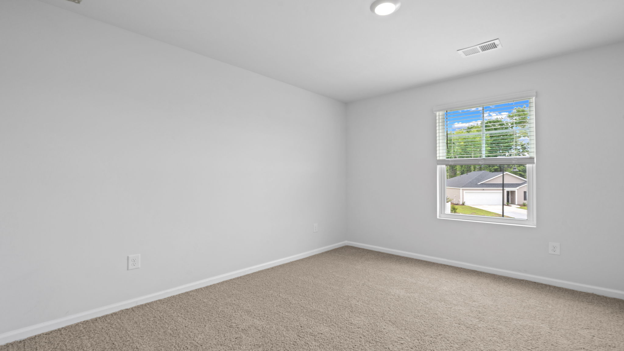 Comfortable guest bedroom in the Downing floor plan at Rice Hope featuring spacious accommodations, abundant natural light, and versatile living space for family members or visitors.