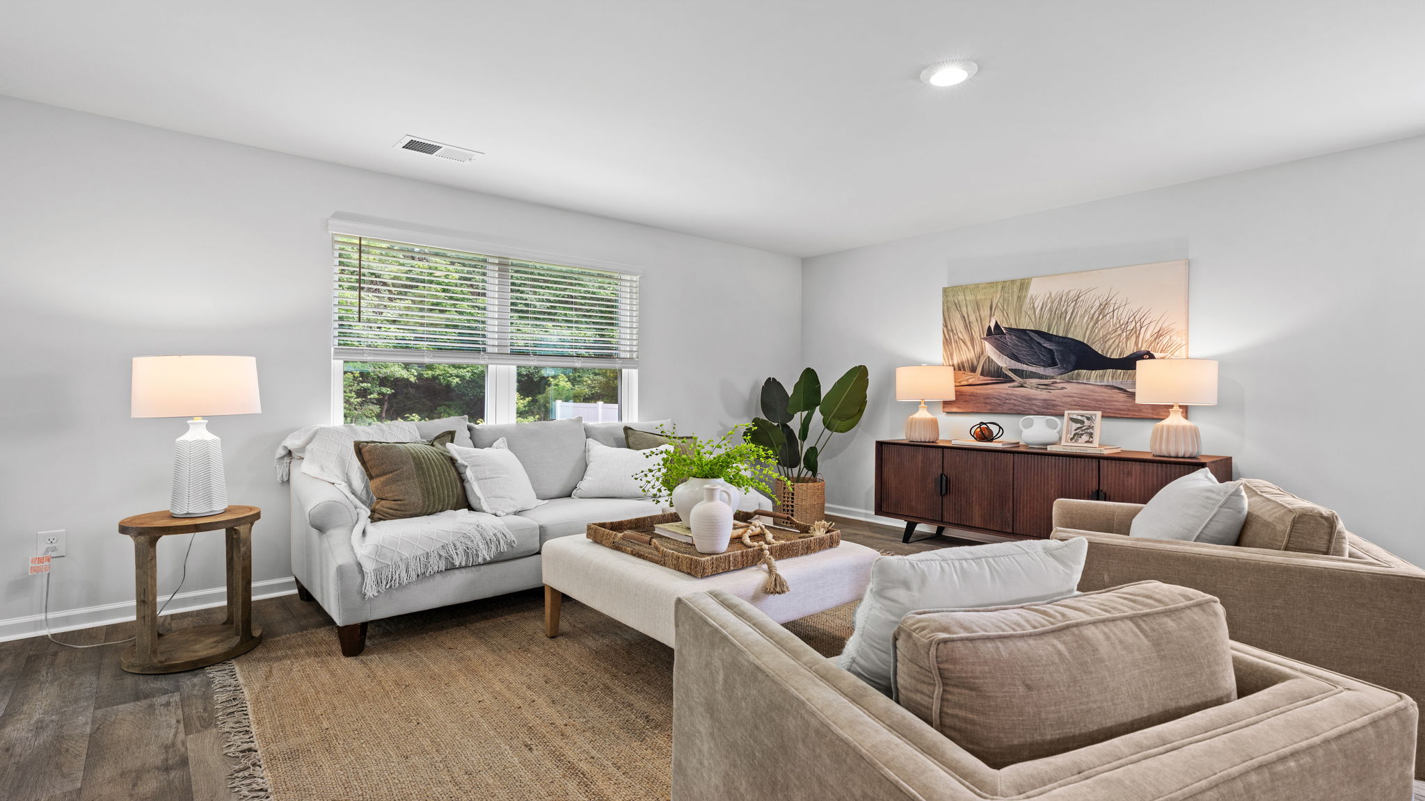 Inviting family room in the Downing floor plan by D.R. Horton showcasing large windows, modern finishes, and seamless connectivity to the kitchen and dining areas.
