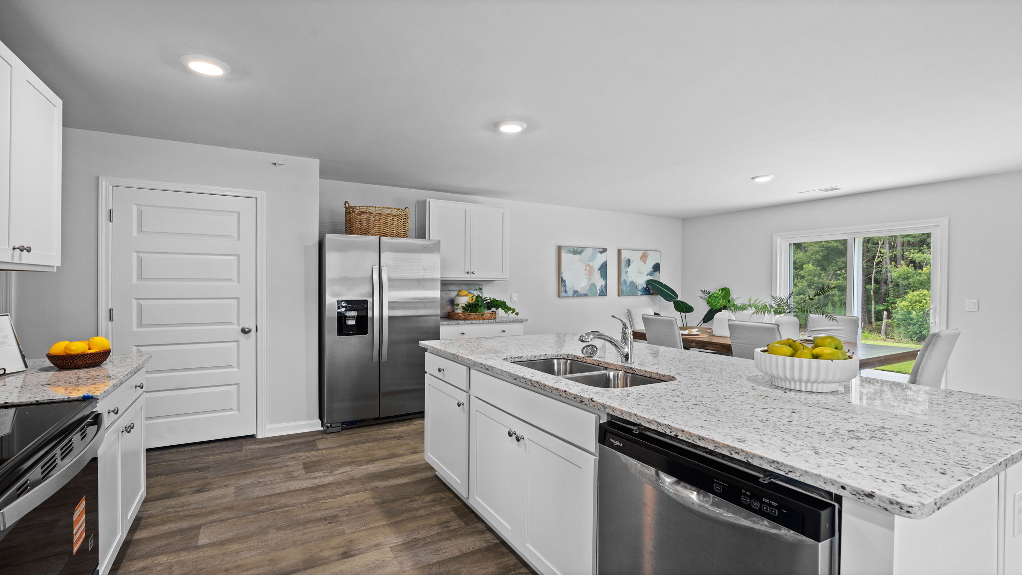 Beautiful kitchen in the Downing floor plan by D.R. Horton in Rice Hope showcasing abundant cabinet storage, contemporary finishes, ample counter space, and seamless flow into the dining and living areas.