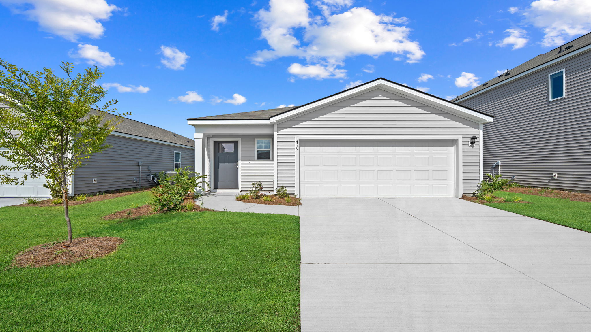 The Willow by D.R. Horton featuring attractive curb appeal, modern exterior design, covered entry, and two-car garage.