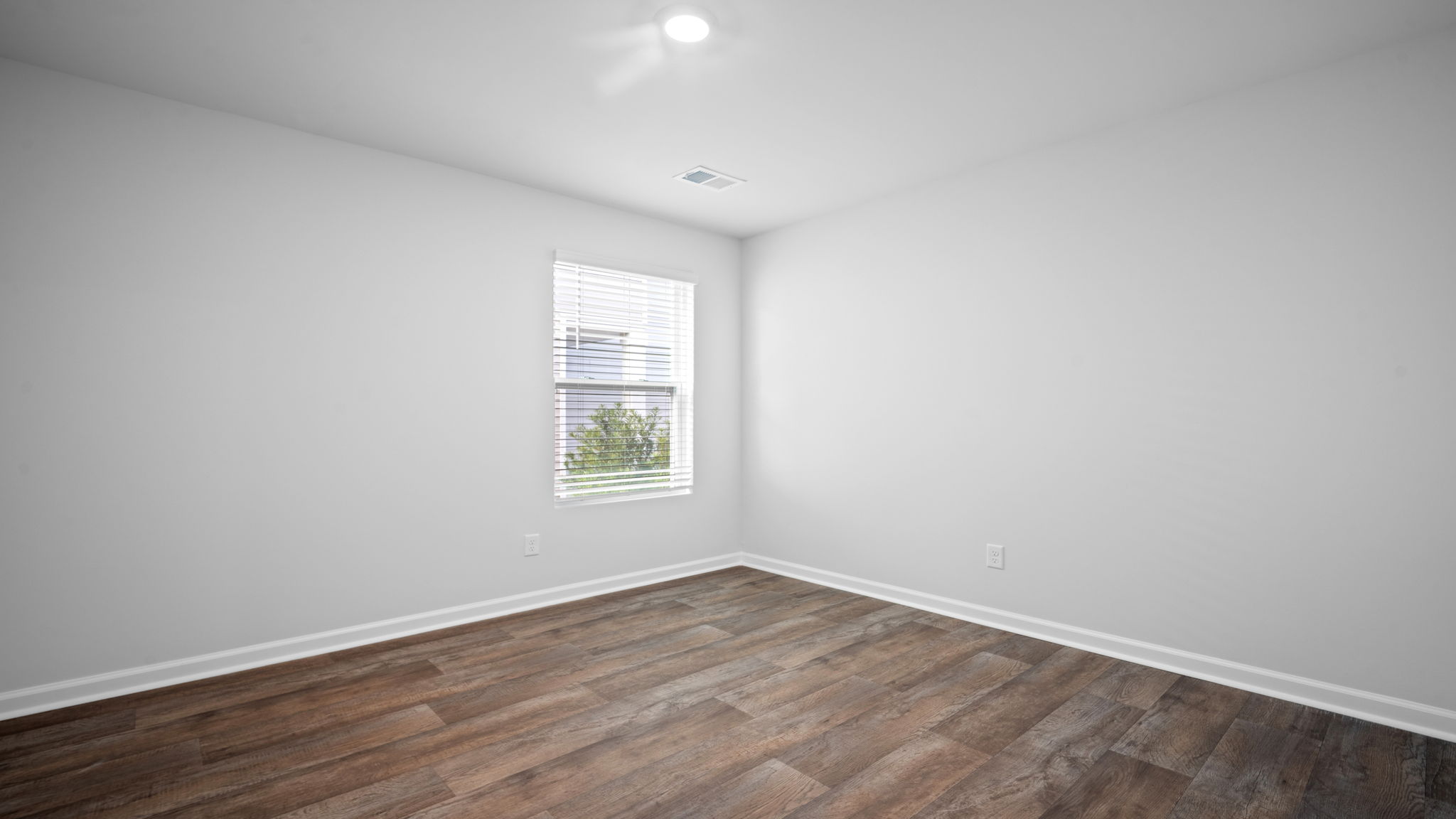 Guest bedroom with bed and window lighting.