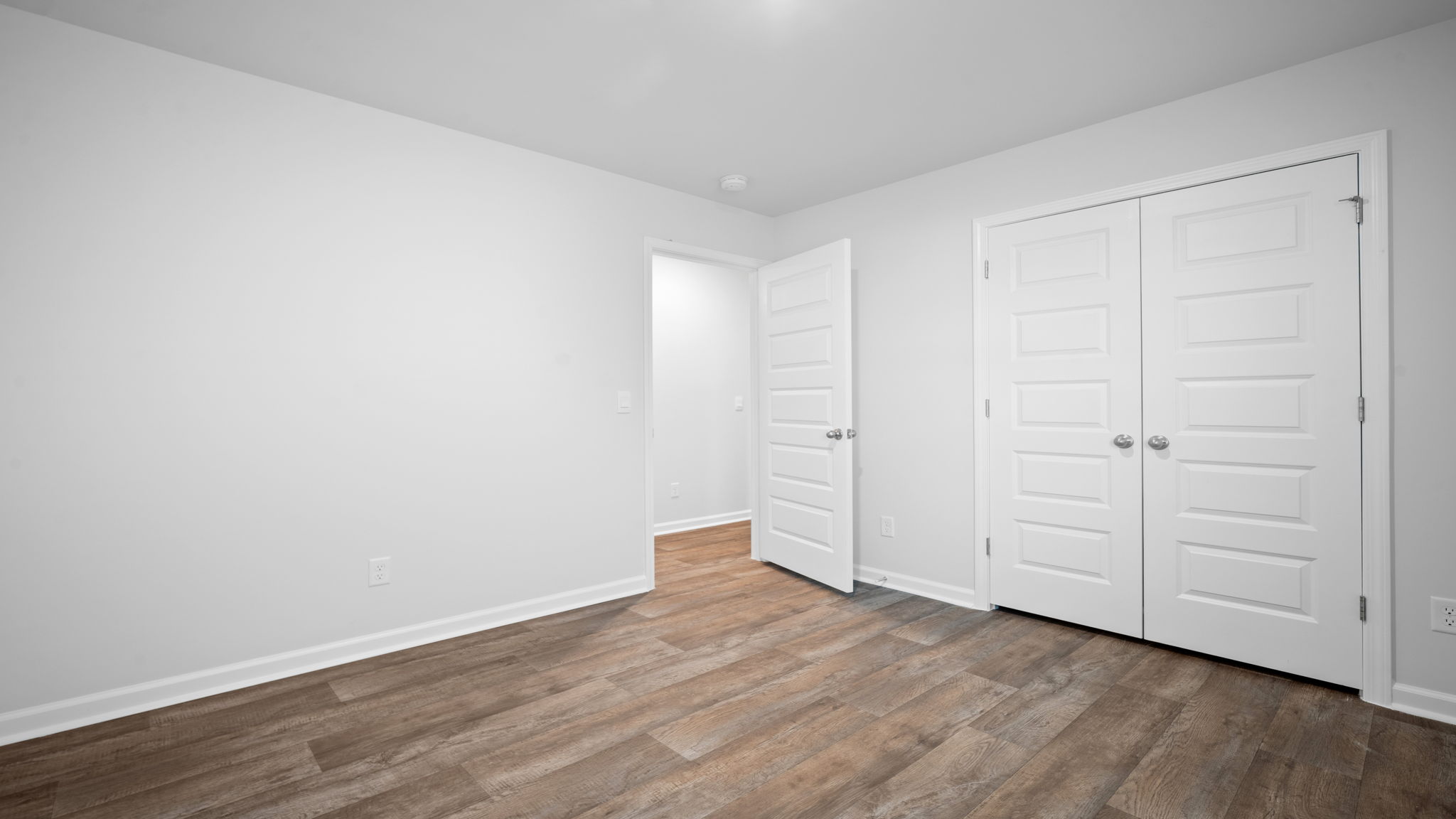 Guest bedroom with bed and window lighting.