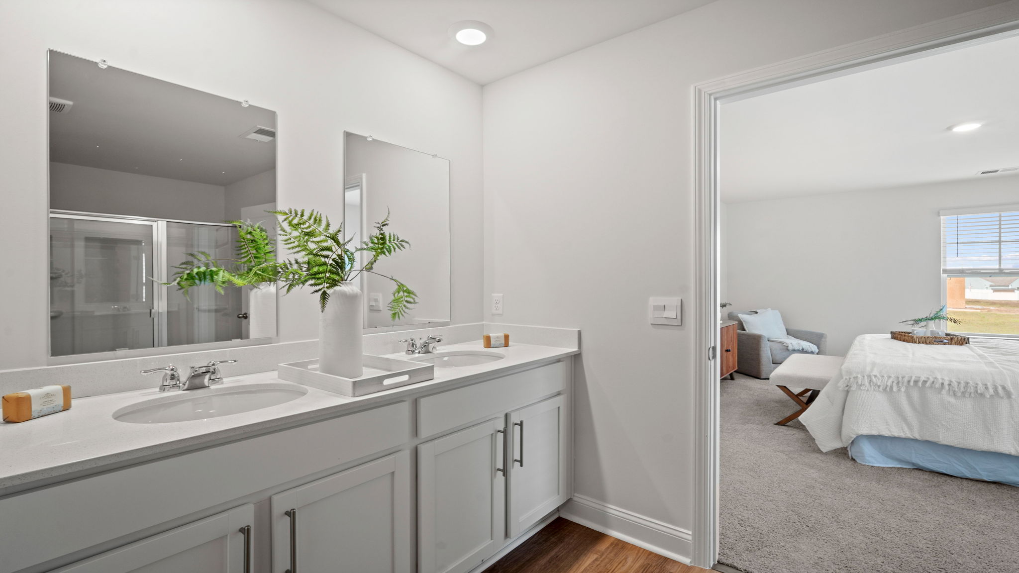 Primary bathroom with tile walk in shower, bright light fixtures, and with built in shelves.