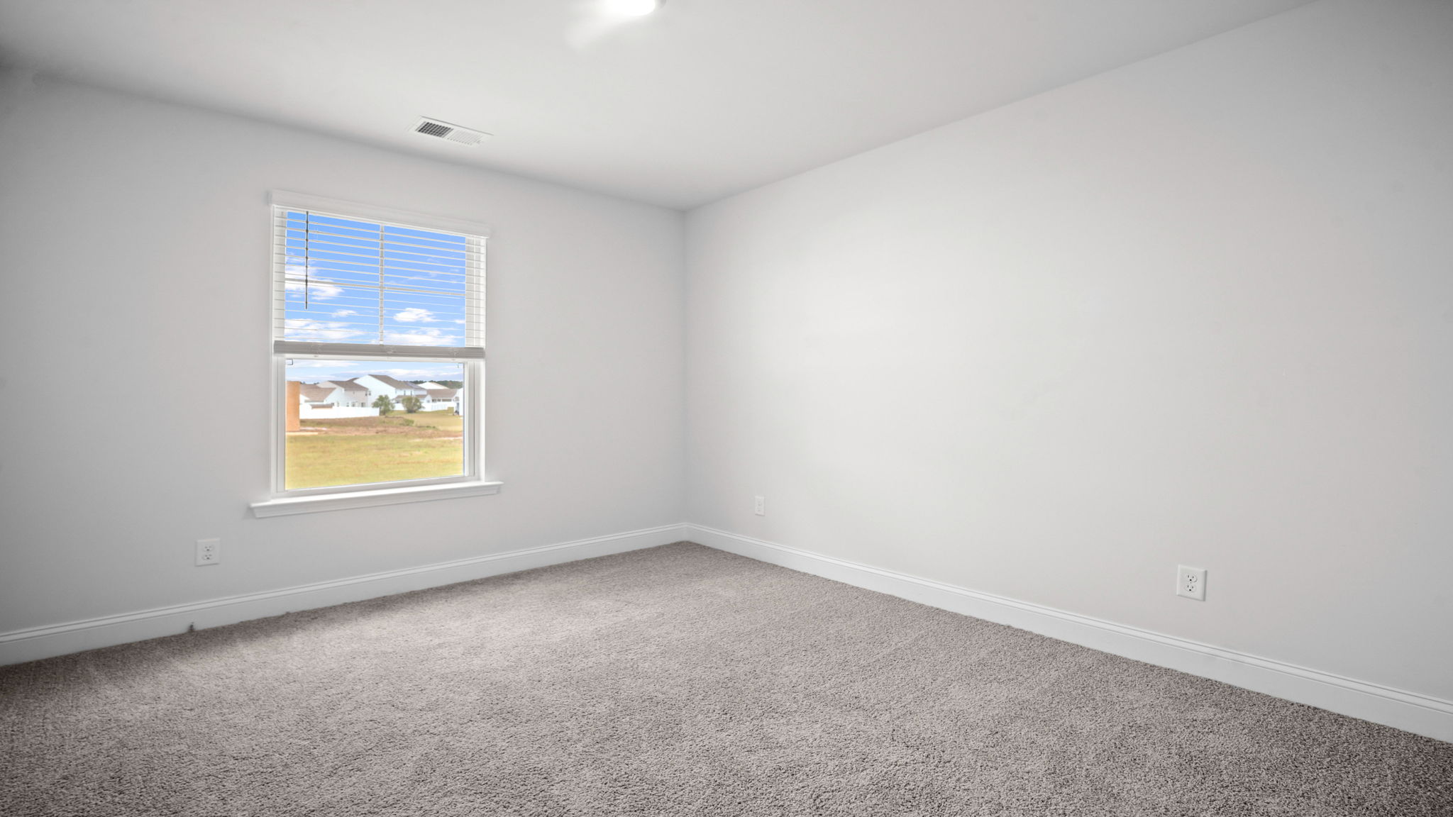 Bedroom with carpeted floors and large single window for natural light.