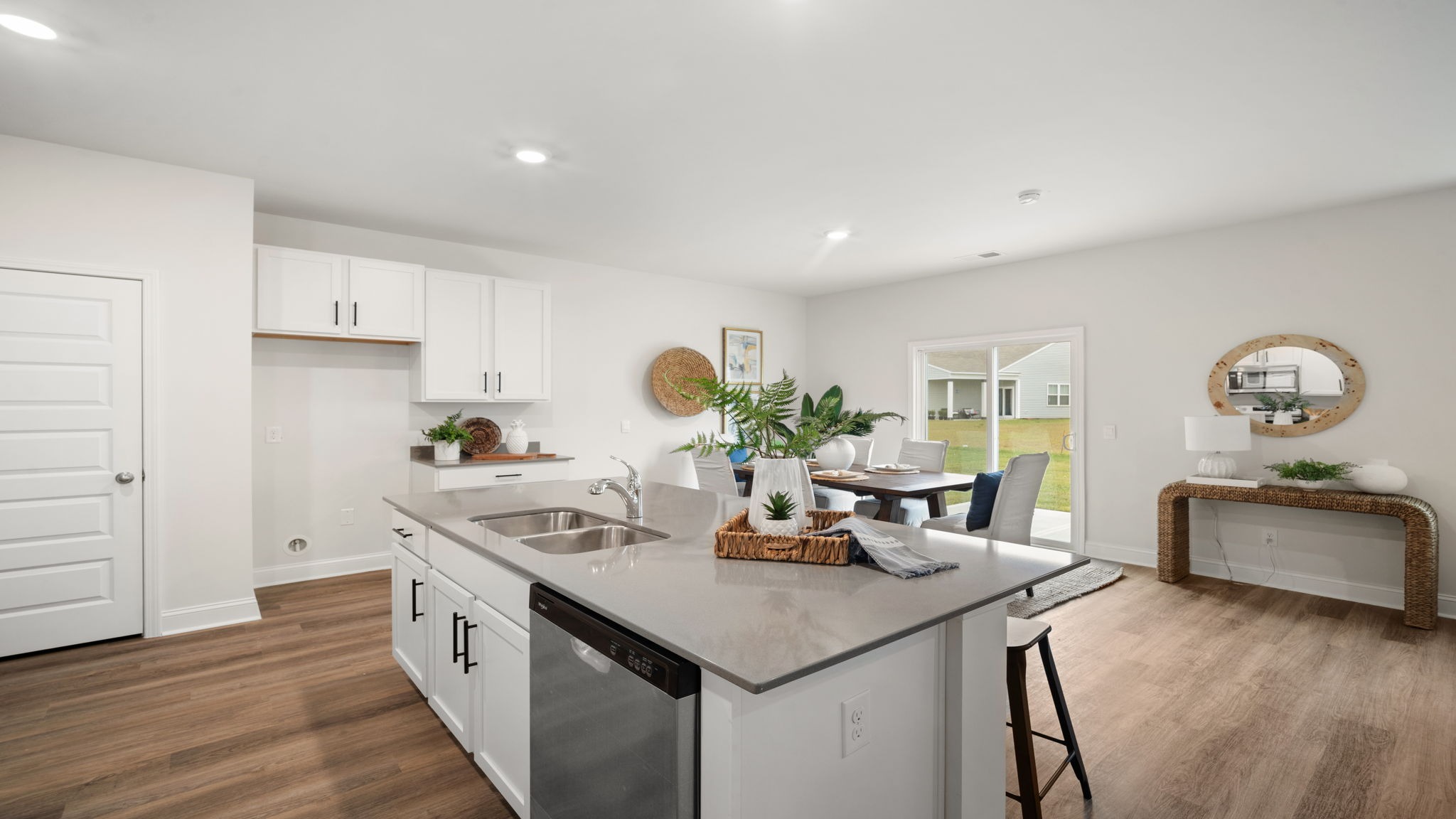 Modern kitchen in the Belhaven floorplan by D.R. Horton featuring a spacious center island, stainless steel appliances, designer cabinetry, and an open-concept layout ideal for cooking and entertaining.