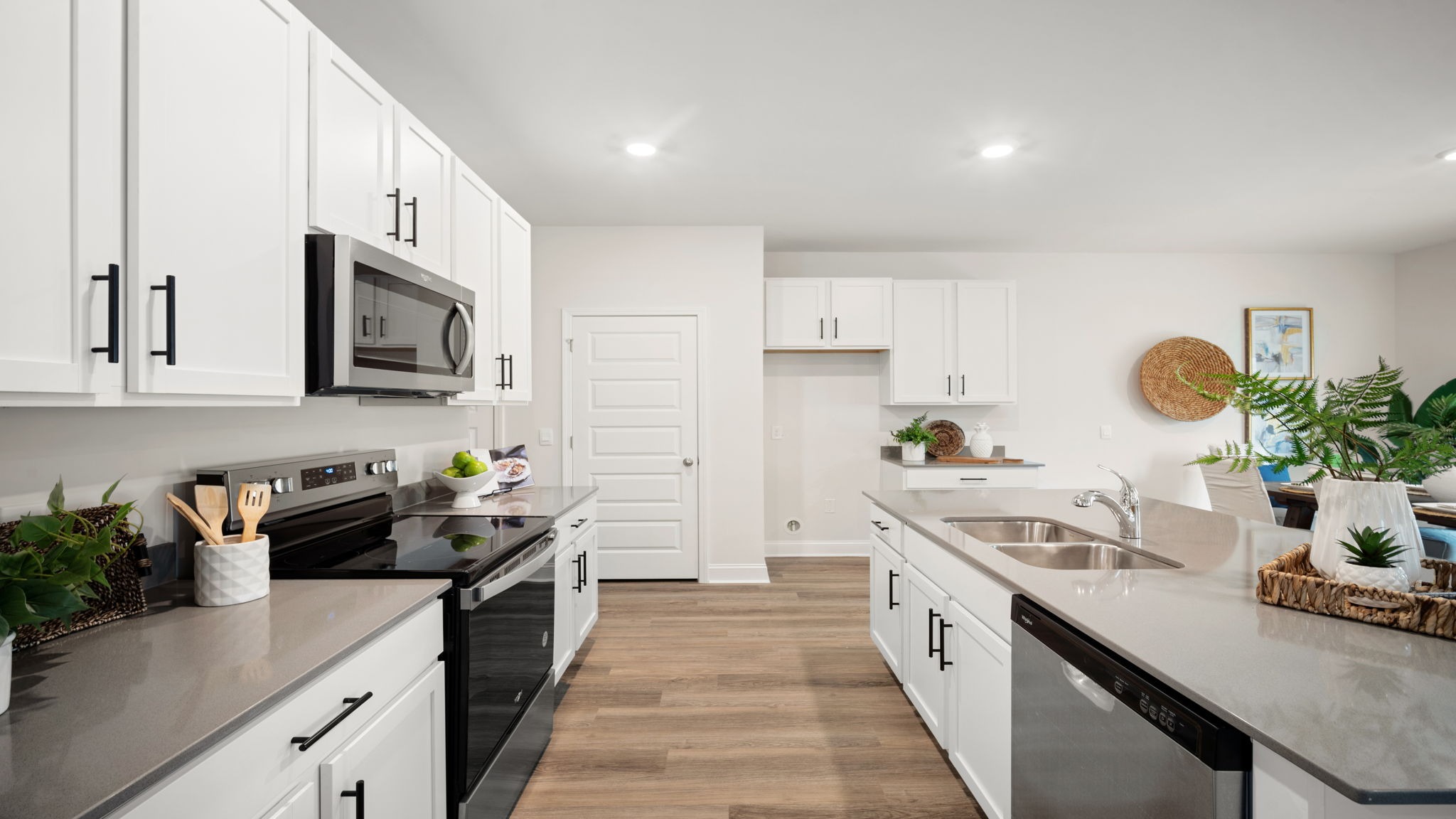Bright kitchen in the Belhaven by D.R. Horton showcasing abundant cabinet storage, expansive countertops, contemporary finishes, and seamless flow into the dining and living areas.