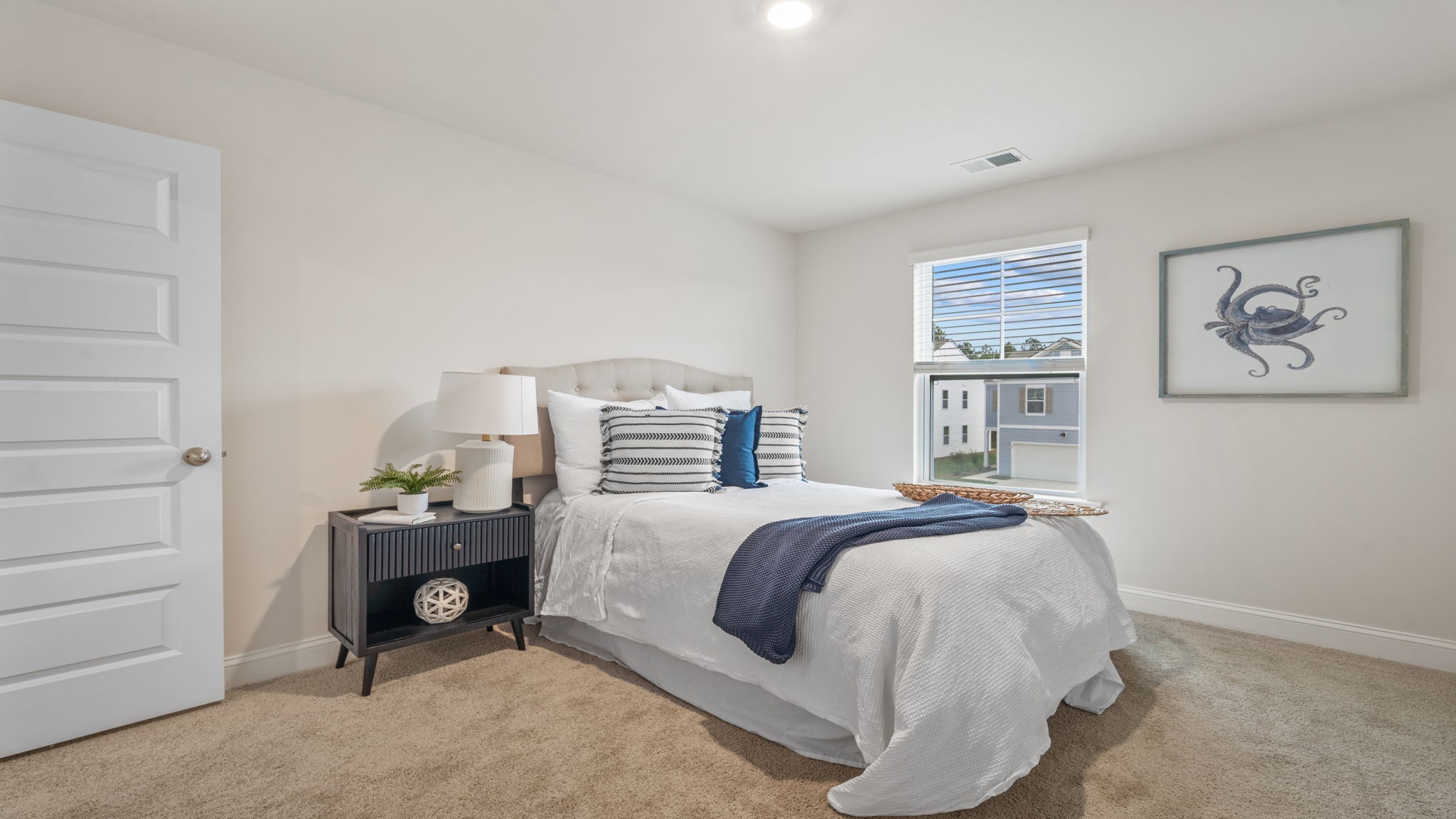 Bright secondary bedroom in the Belhaven showcasing ample closet storage, contemporary design elements, and a welcoming atmosphere for family members or guests.