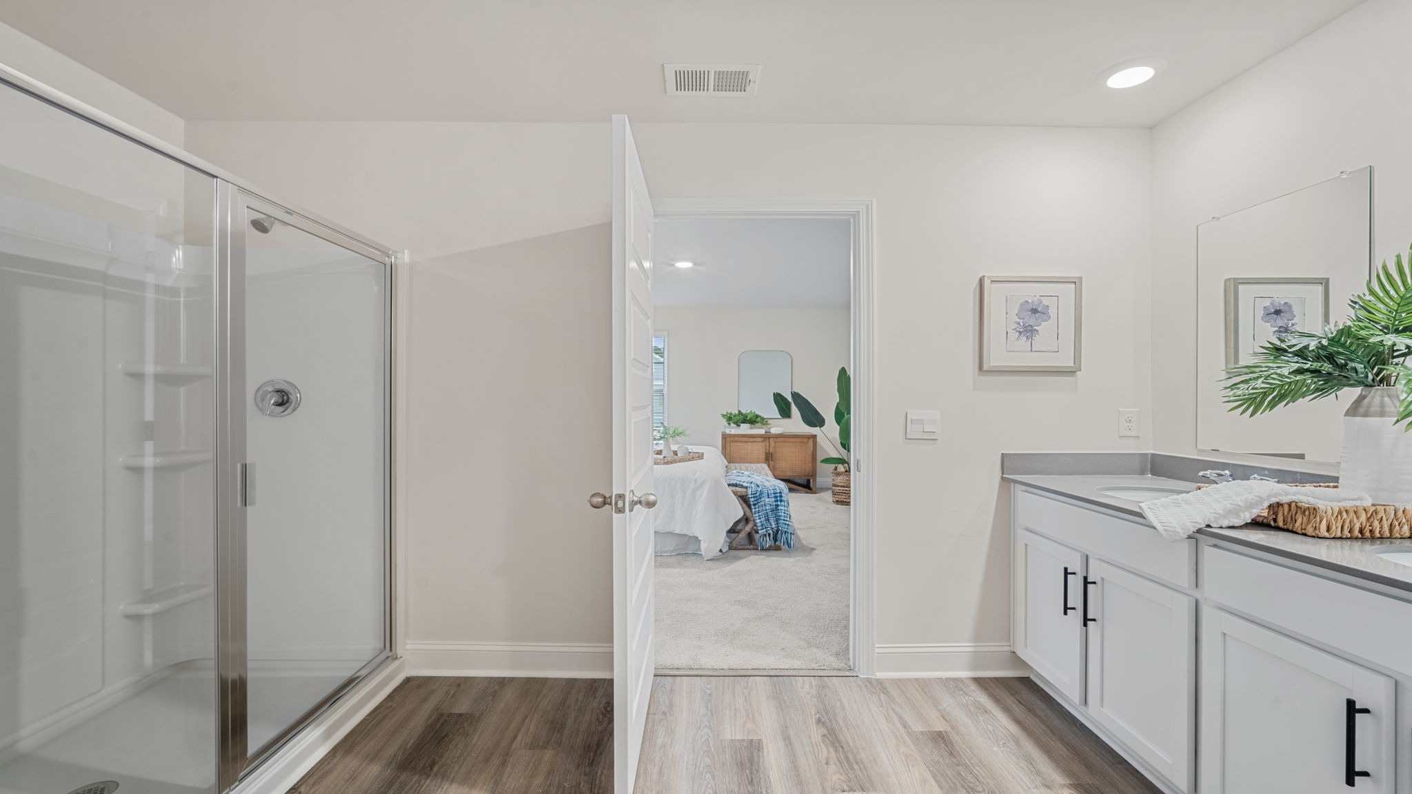 Elegant owner's bathroom in the Belhaven showcasing contemporary cabinetry, spacious countertops, bright lighting, and sophisticated design details.