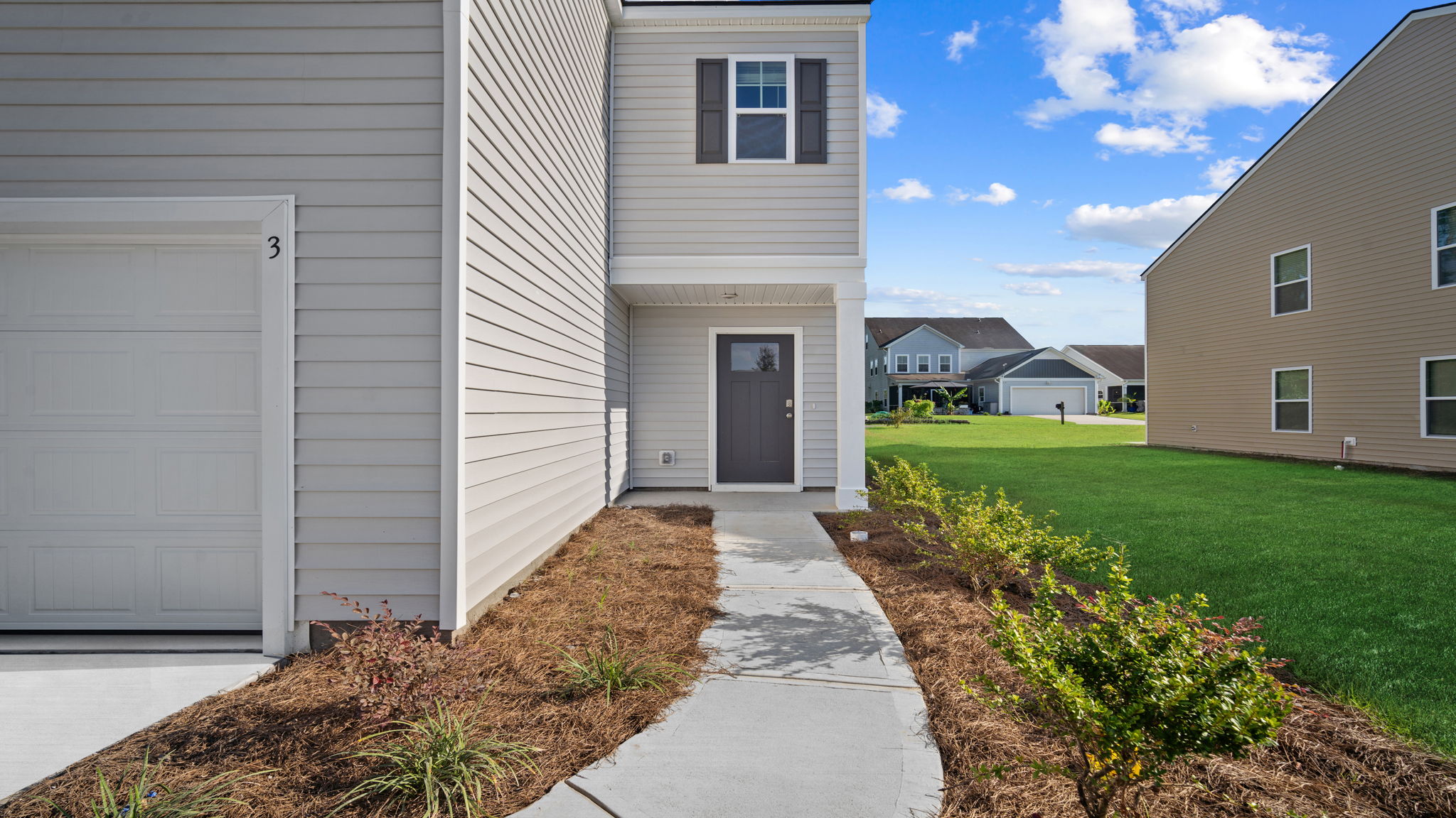 Front porch area with entryway and surrounding landscaping.