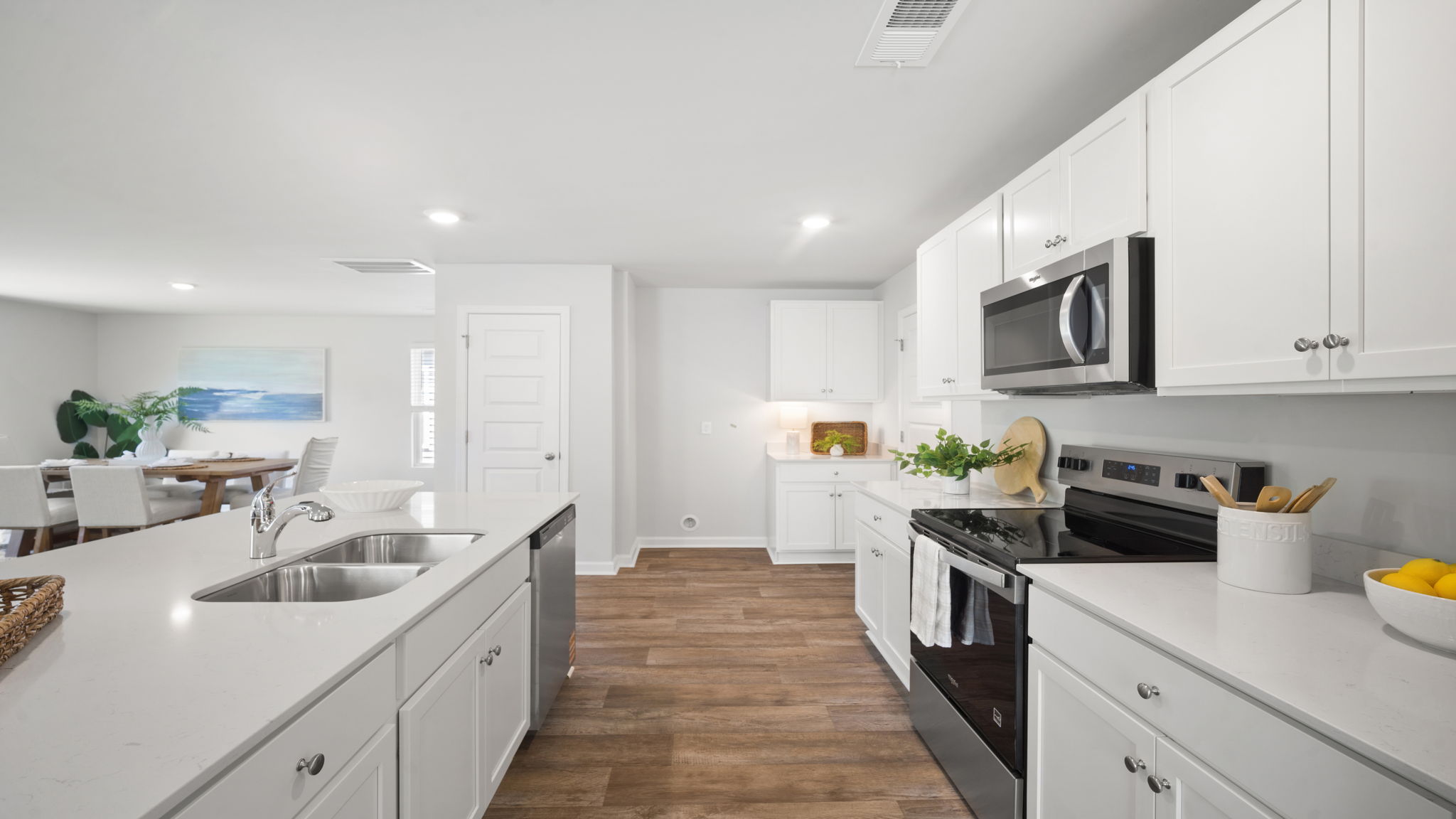 Open-concept kitchen in the Elston home offering modern finishes, abundant cabinet space, and seamless flow into the dining and living areas.