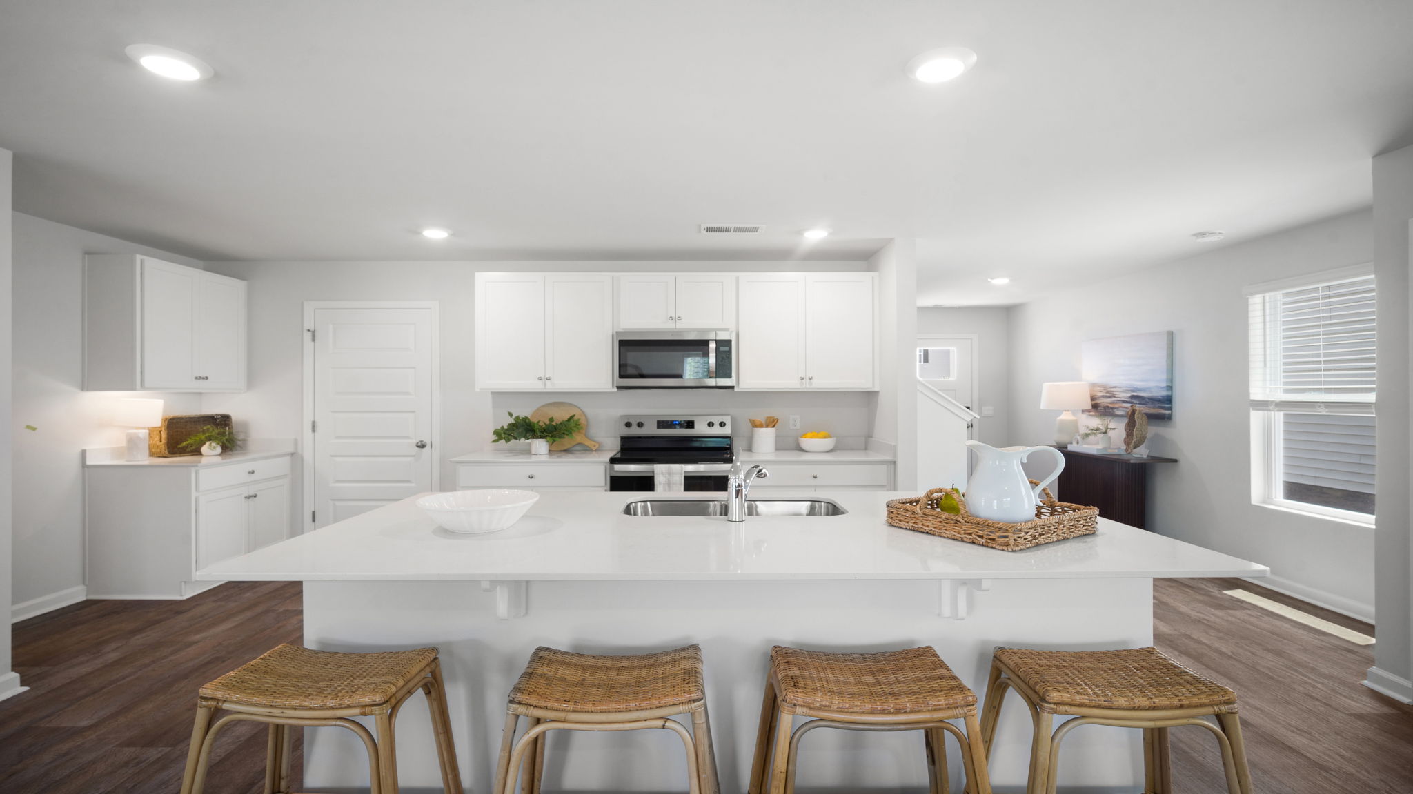 Chef-inspired kitchen in the Elston floorplan featuring quartz countertops, modern cabinetry, stainless steel appliances, and a large island ideal for meal preparation and entertaining.
