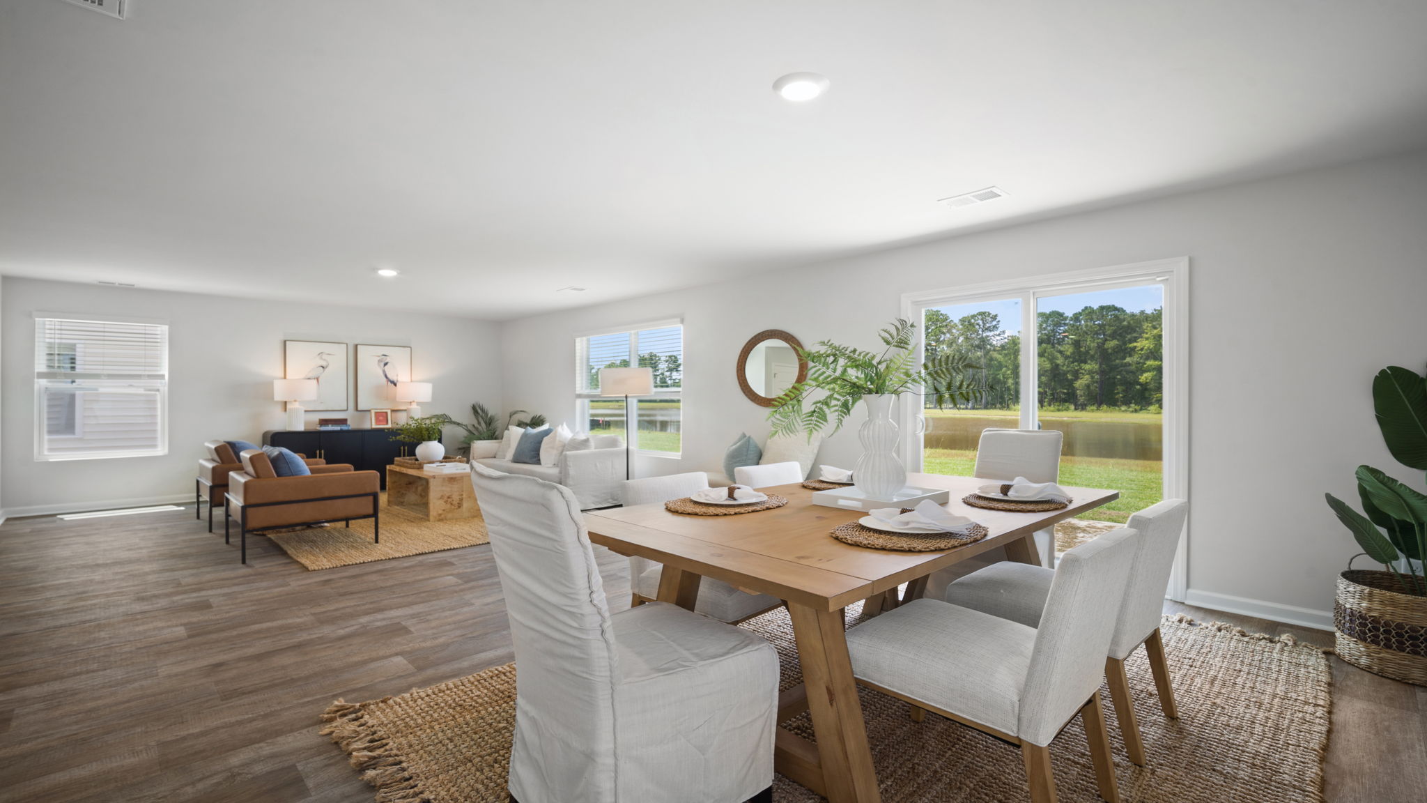 A spacious open floor plan living room and kitchen area with hardwood floors, and trey ceilings.