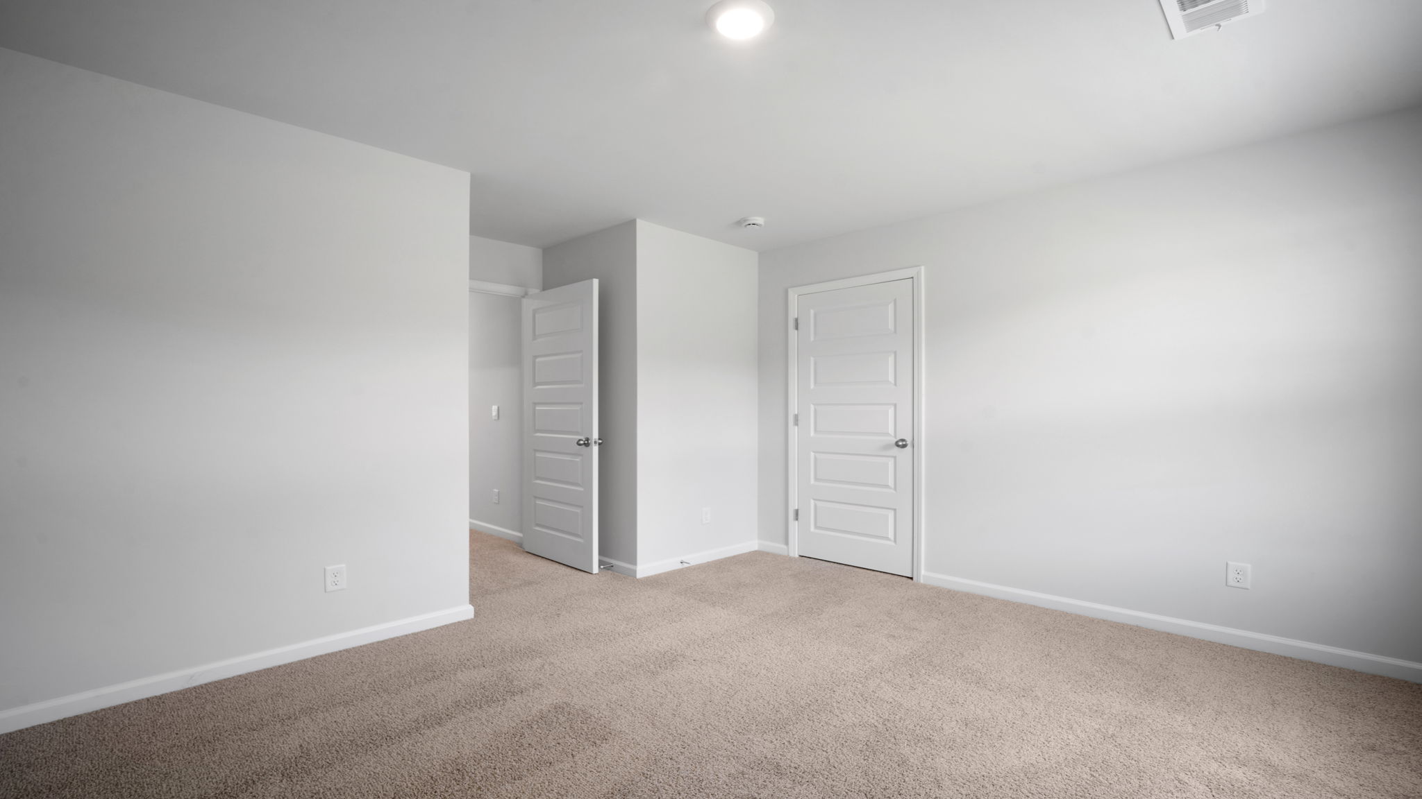 Guest bedroom with bed and window lighting.