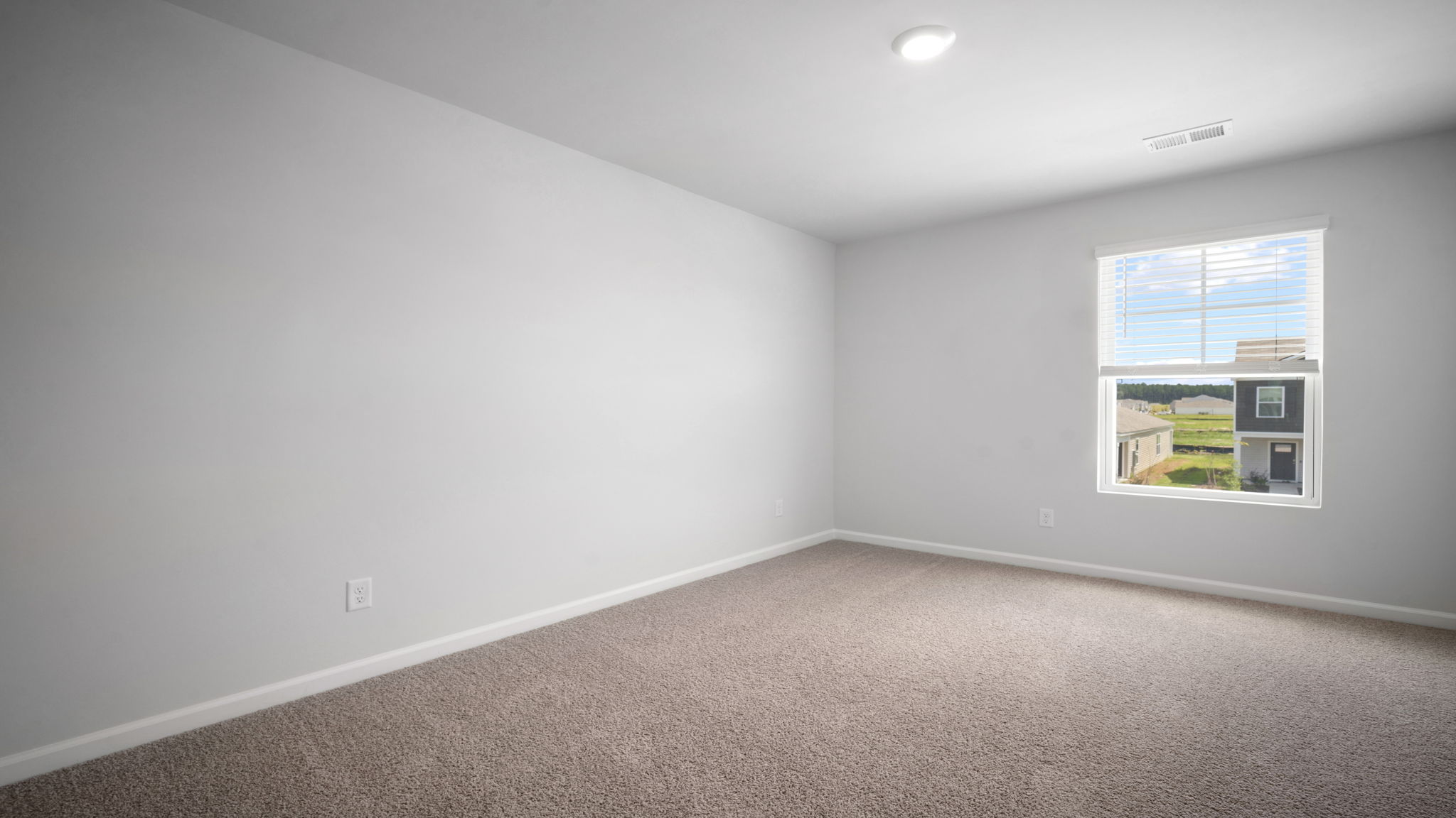 Guest bedroom with bed and window lighting.