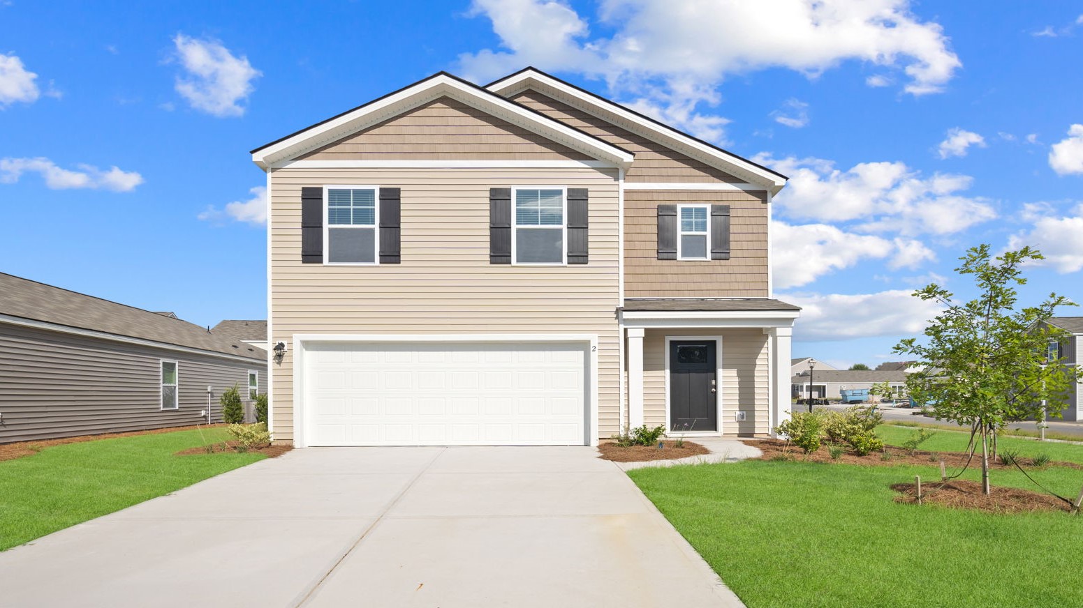 Front exterior view of a two-story home with driveway and lawn.