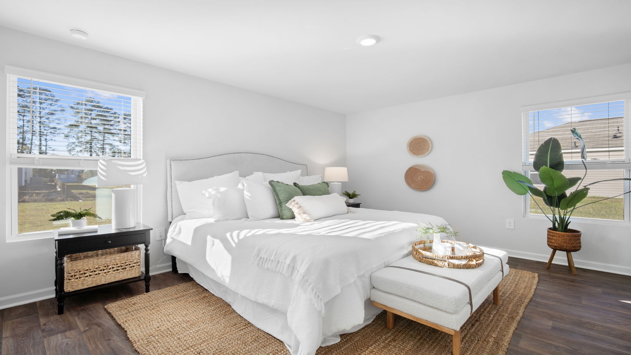 Primary bedroom decorated with a bed, side table, and bench