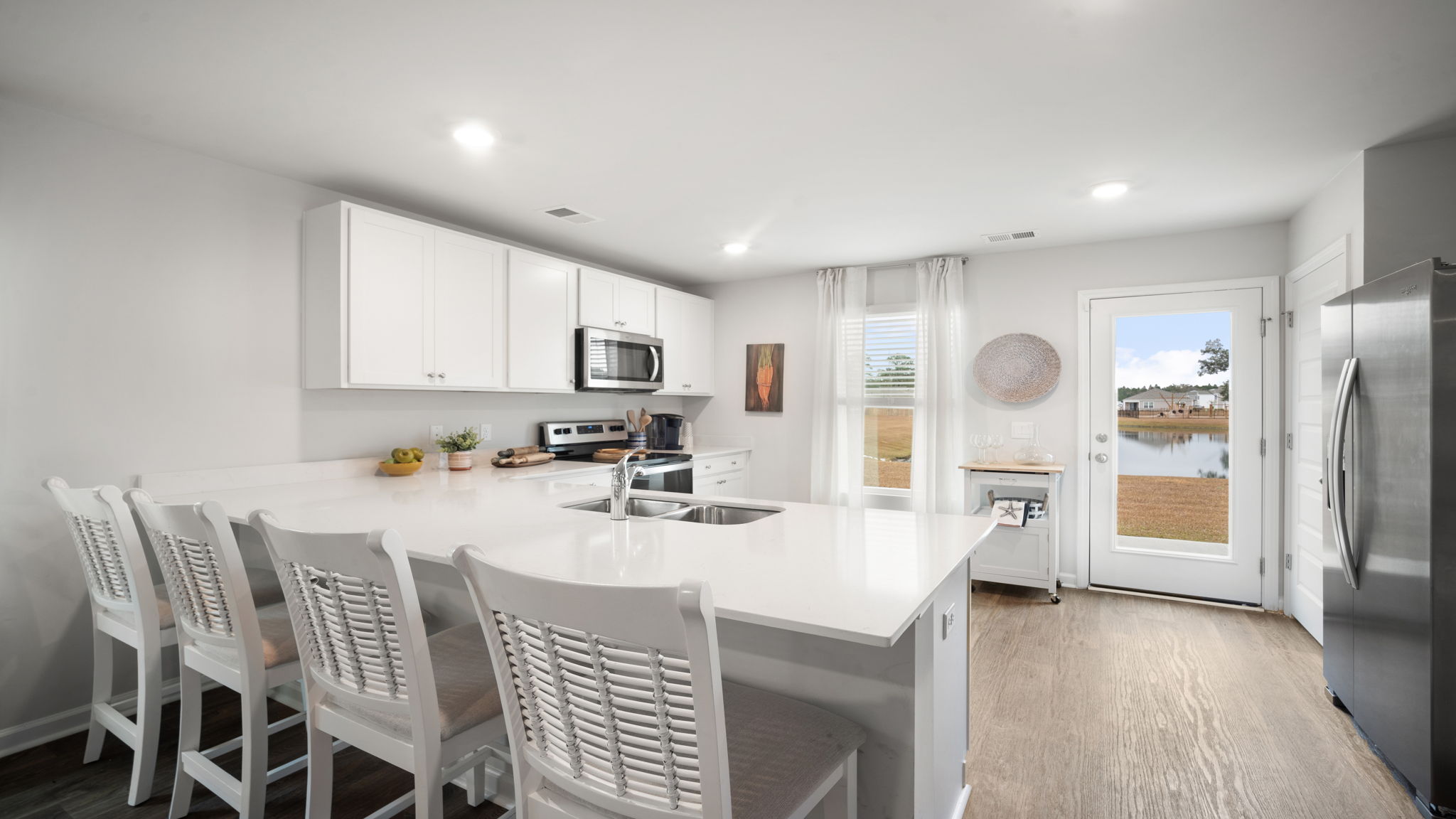 Lewis floorplan kitchen with open-concept design, ample cabinetry, and seamless flow to living area in Rice Hope