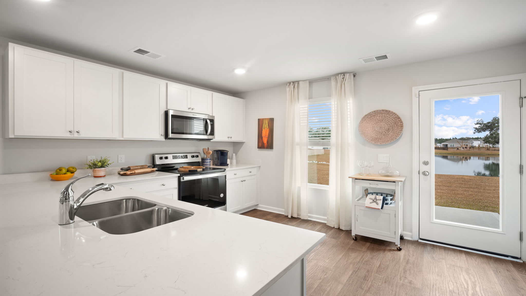 Lewis floorplan kitchen with open-concept design, ample cabinetry, and seamless flow to living area in Rice Hope