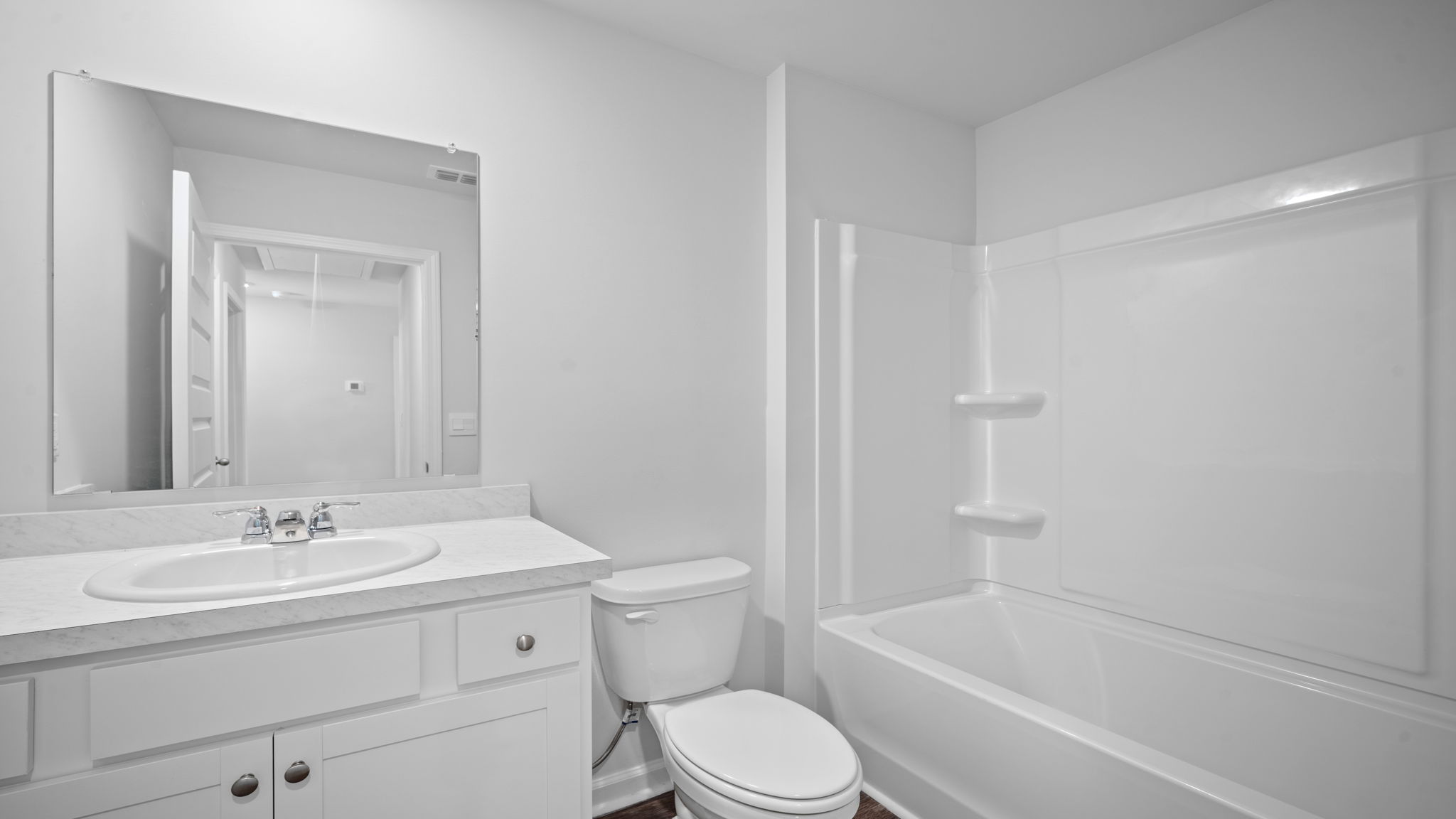 .Bathroom with single sink vanity, with shower and tub combination and built in shelving.