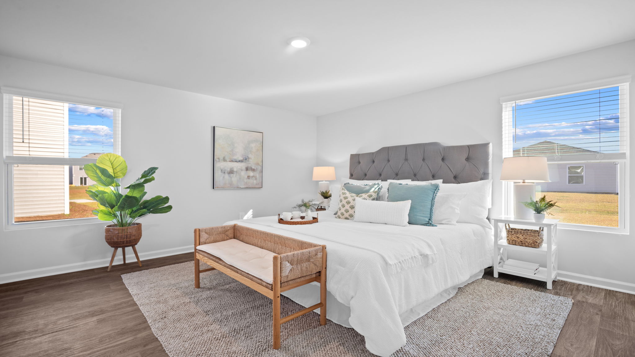 Primary bedroom with carpeted floors, large windows, and trey ceilings.