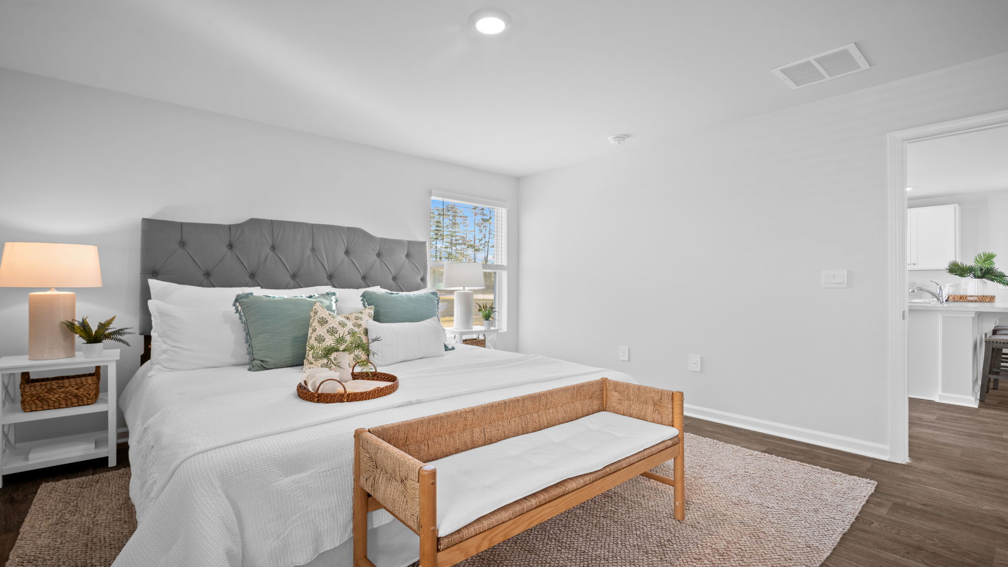 Luxurious primary bedroom in the Lewis floor plan showcasing elegant finishes, large windows, generous living space, and convenient access to a spa-inspired bathroom.