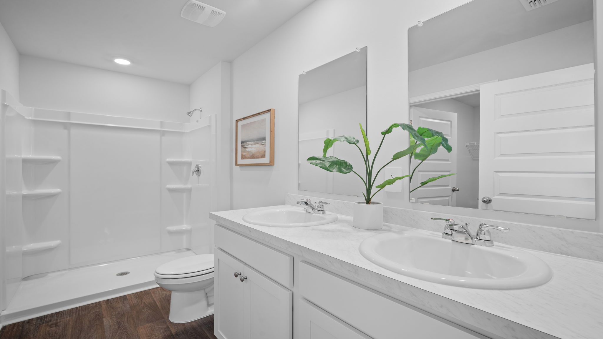 Spa-inspired primary bathroom in the Lewis floor plan by D.R. Horton showcasing a dual-sink vanity, walk-in shower, modern fixtures, ample storage, and designer-selected finishes for everyday comfort.