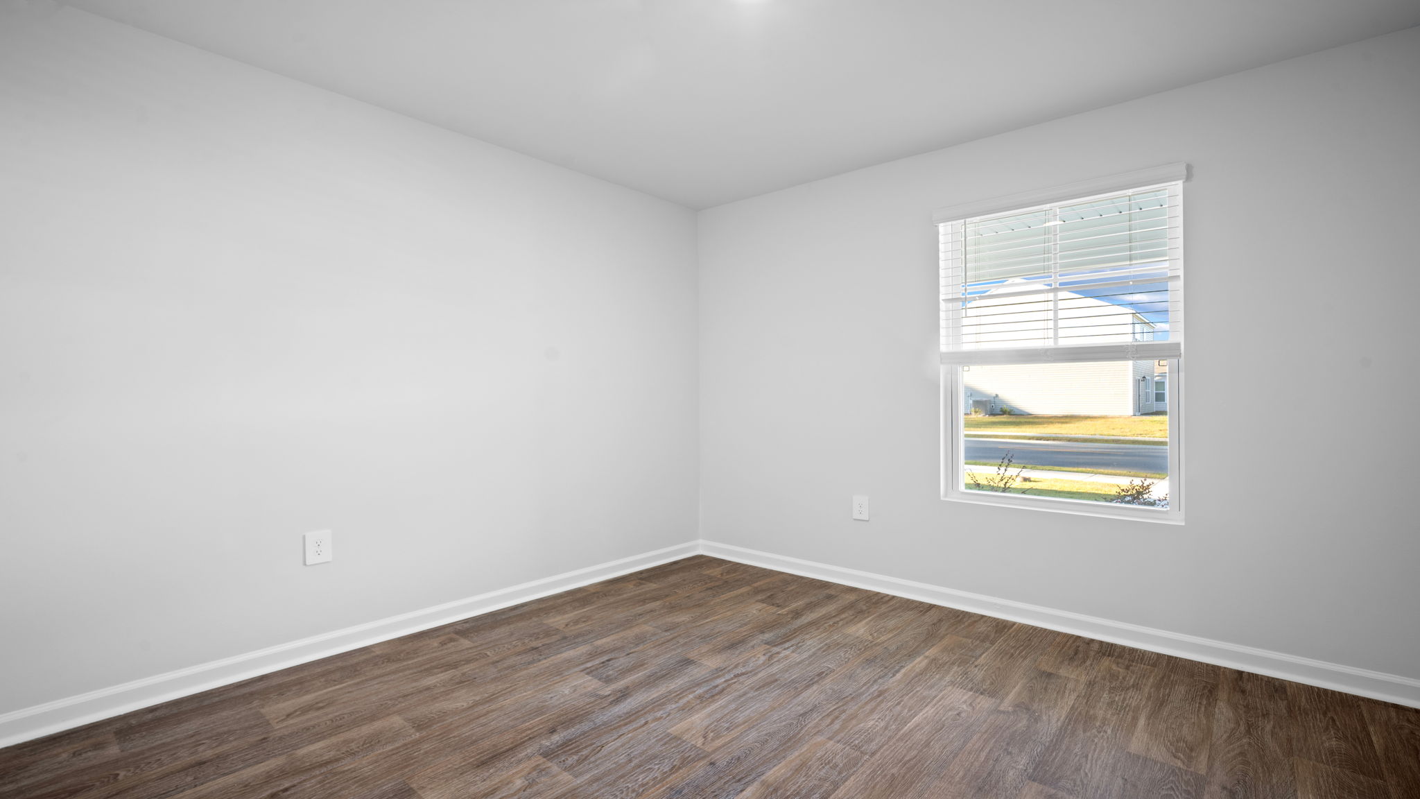 Comfortable guest bedroom in the Lewis floor plan at Rice Hope featuring abundant natural light, spacious closet storage, contemporary finishes, and flexible living space for family, guests, or a home office.