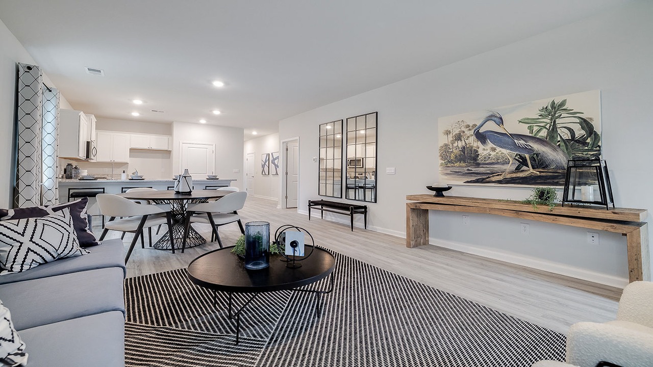 Spacious living room in the Helena floor plan at Rice Hope by D.R. Horton featuring an open-concept design, large windows, abundant natural light, and comfortable gathering space for family and friends