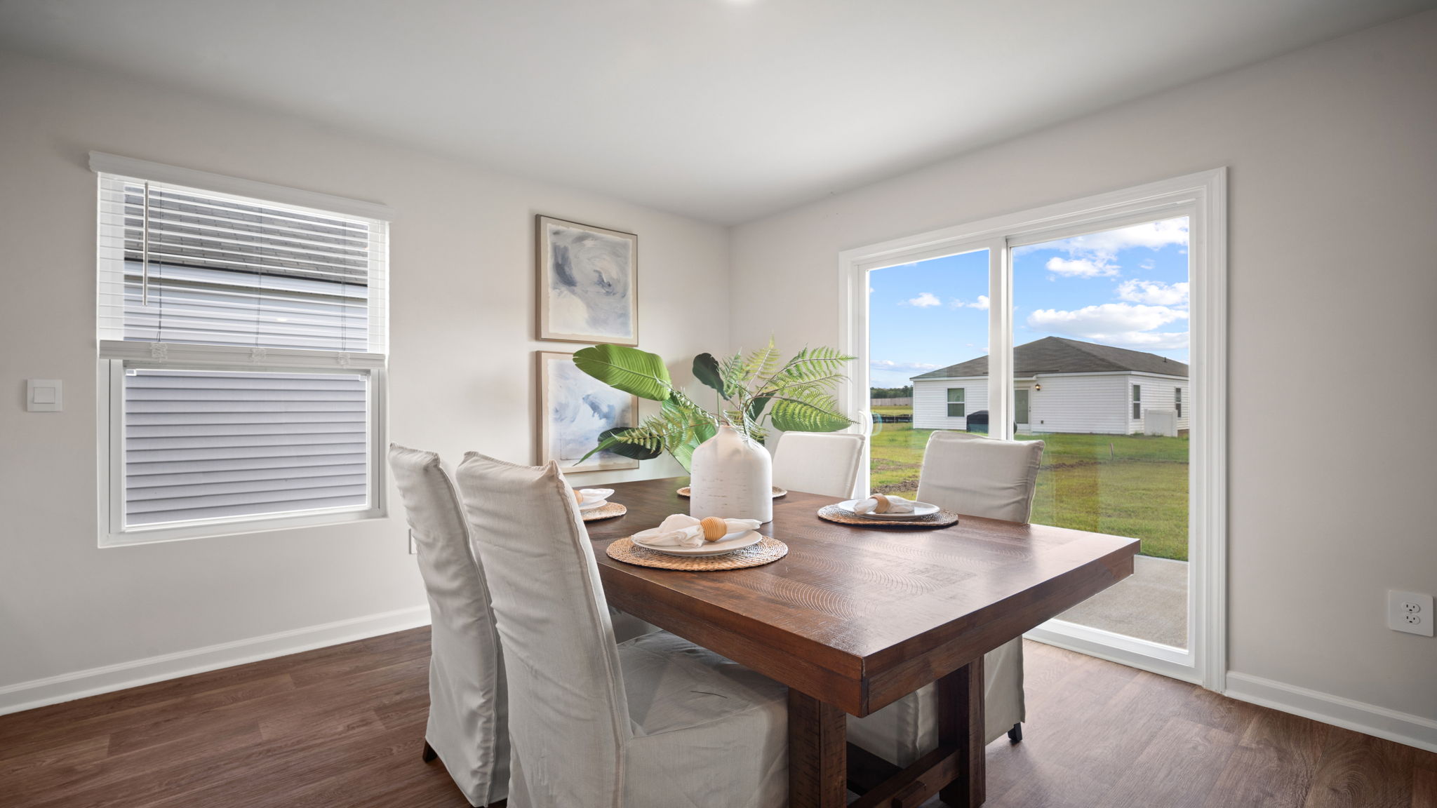 The dining area with hardwood floors with large windows for natural lighting.