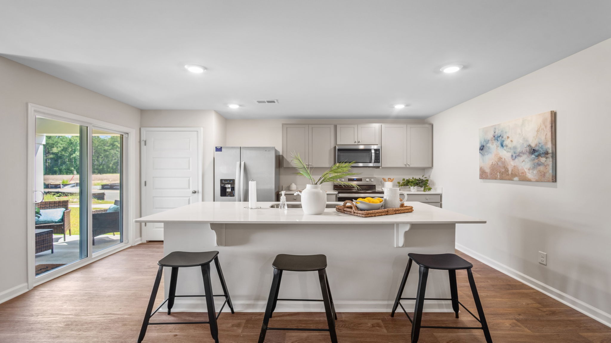 Bright open-concept kitchen with modern finishes, island seating, and seamless flow to the dining and living areas in the Kerry floor plan.