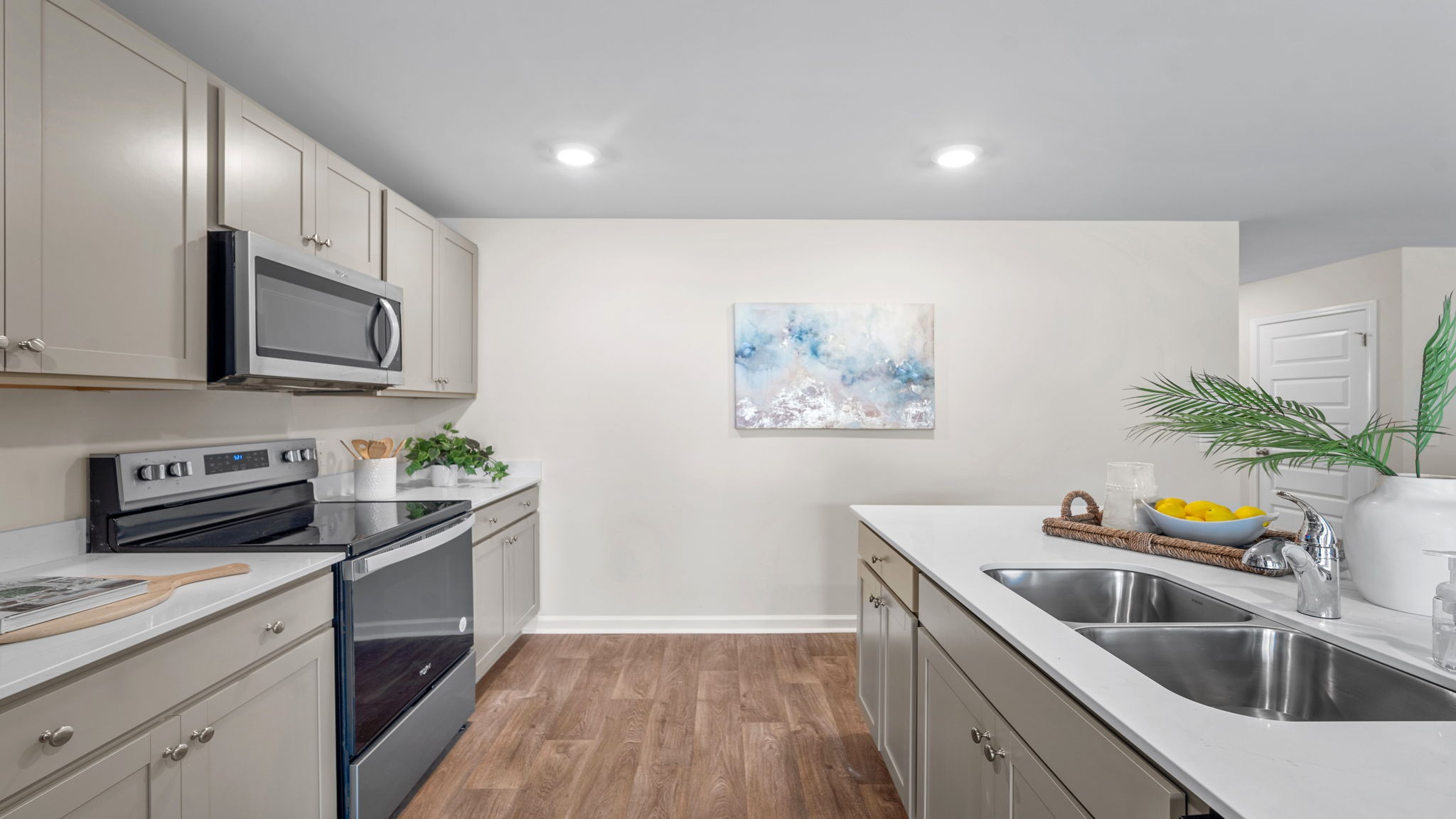 Bright open-concept kitchen with modern finishes, island seating, and seamless flow to the dining and living areas in the Kerry floor plan.